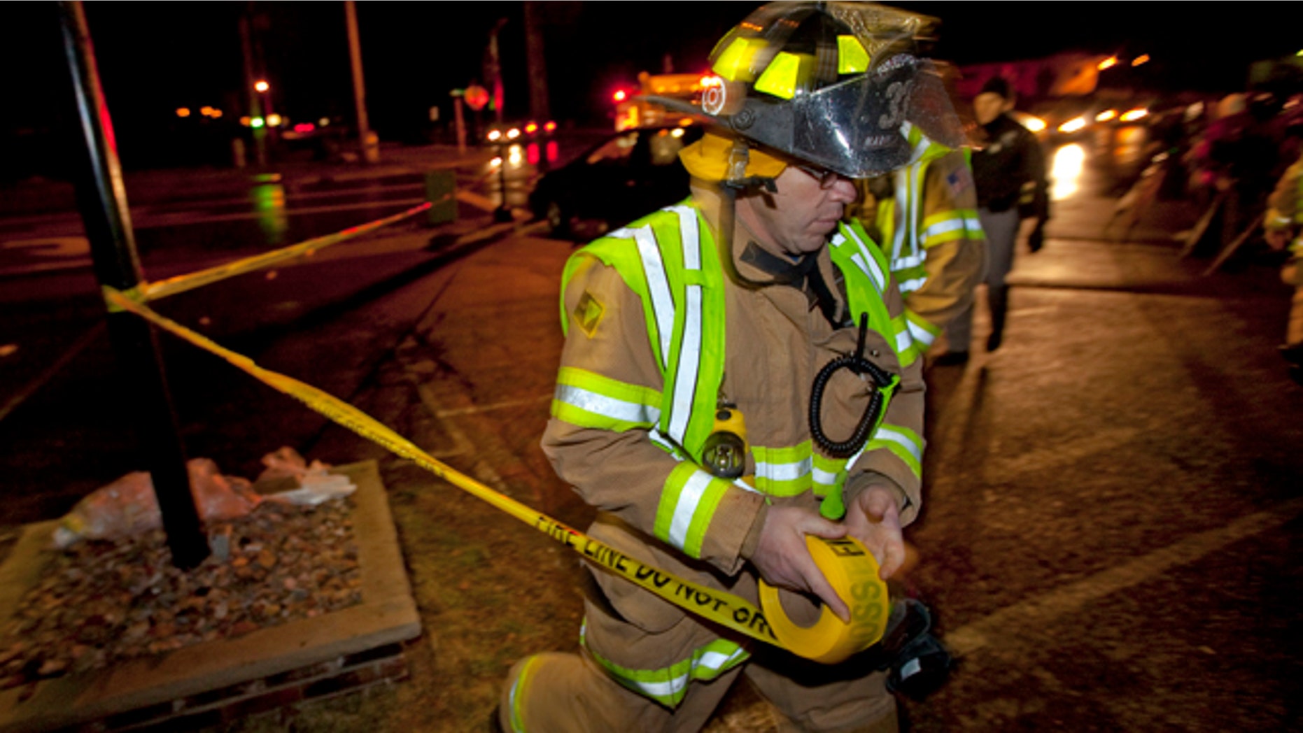 Nov. 29, 2010: A firefighter sets up a tape line in a parking lot a few blocks from Marinette High School after a student armed with a handgun burst into a classroom at the northern Wisconsin school.