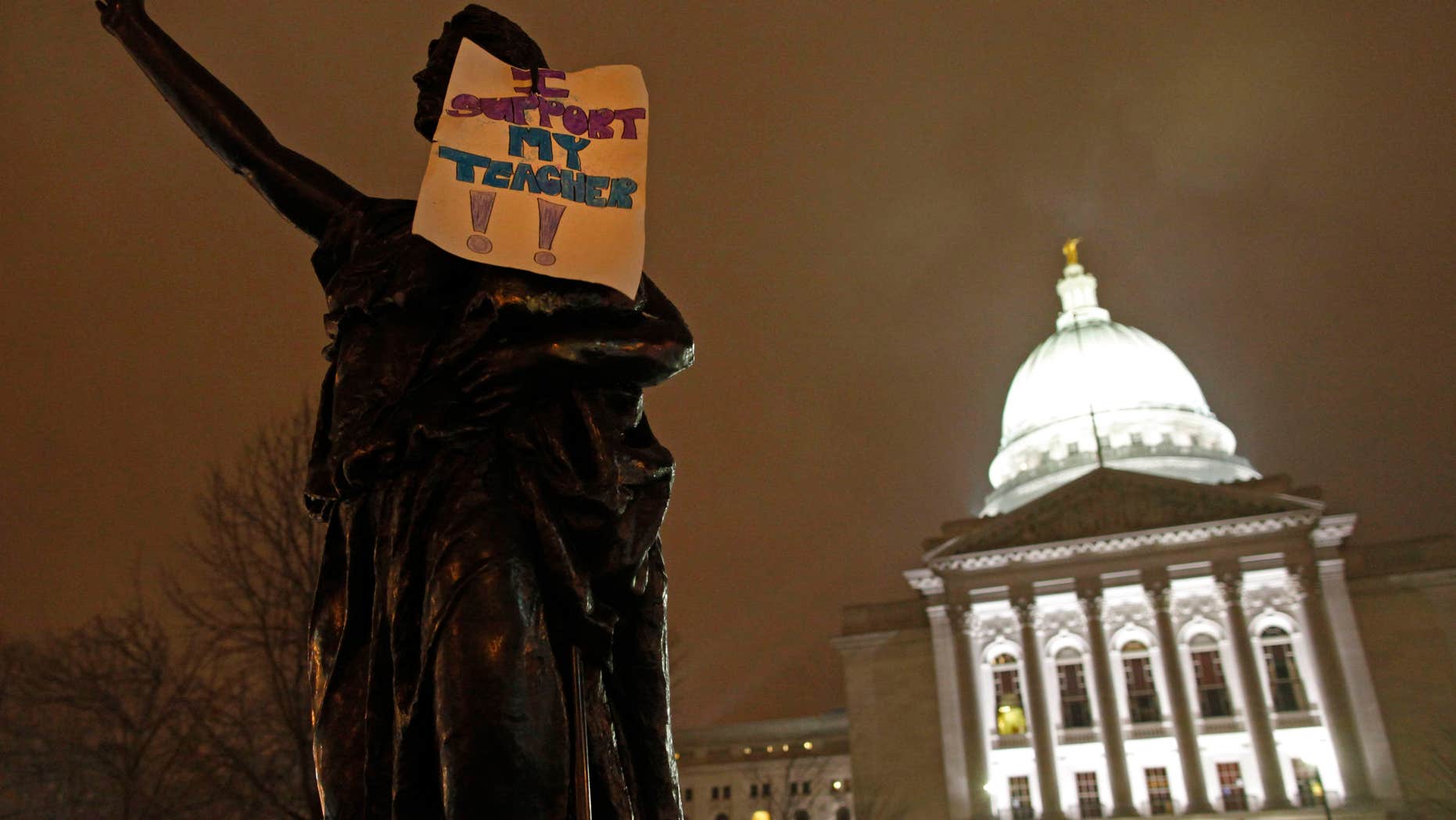February 21: A sign that says "I support my teacher" hangs on a statue outside the state Capitol in Madison, Wis. Twice as many public school teachers decided to retire this year as in each of the past two years.