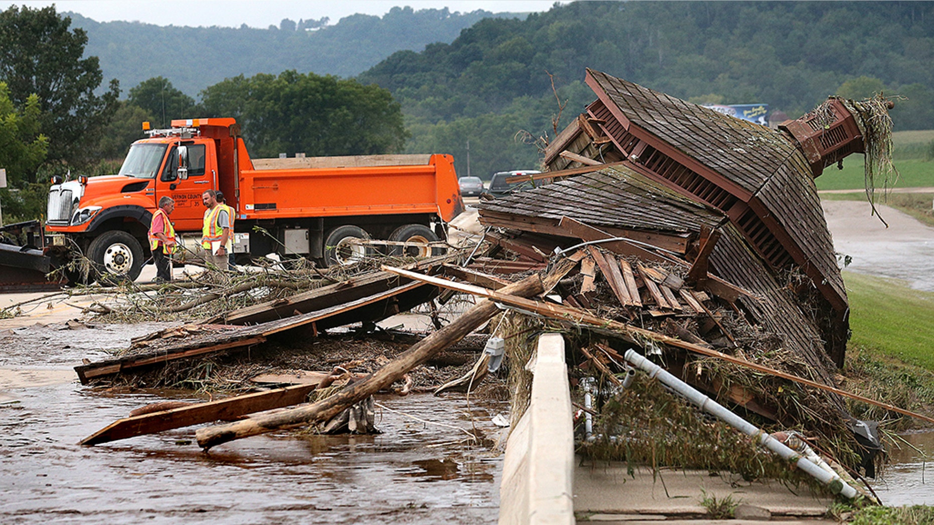 A gazebo from nearby Veterans Memorial Park is seen pinned up against the Hwy. 14/61 bridge Tuesday, Aug. 28, 2018, in Coon Valley, Wis., moved there by flood water from Coon Creek. Rain continued to fall through early Tuesday in eastern Wisconsin with another heavy round expected Tuesday night into Wednesday. (Peter Thomson/La Crosse Tribune via AP)
