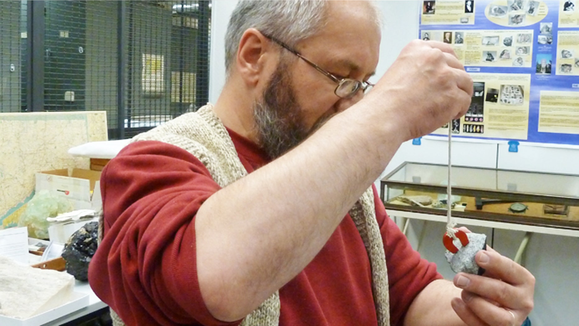 Yale Peabody Museum mineralogist Stefan Nicolescu evaluating the magnetic field of a meteorite that fell on a house in Wolcott, Conn. He is holding the portion of the meteorite (which broke in two upon impact) that was brought to the Peabody.