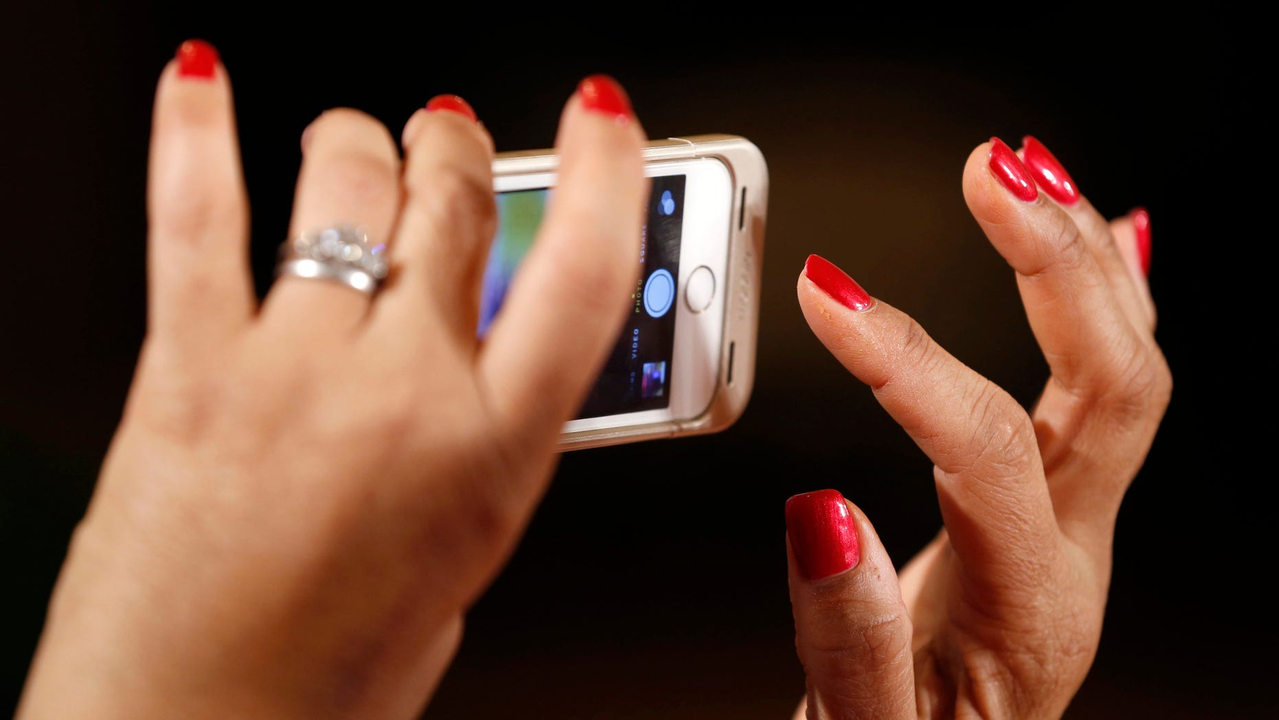 A woman takes a photo as U.S. President Barack Obama holds an event aimed at increasing transparency about women's pay during an event at the White House in Washington April 8, 2014. Obama signed two executive actions, part of a continuing effort by the administration to ensure women are paid equally to their male counterparts for similar work.
REUTERS/Kevin Lamarque (UNITED STATES - Tags: POLITICS BUSINESS EMPLOYMENT) - RTR3KG84