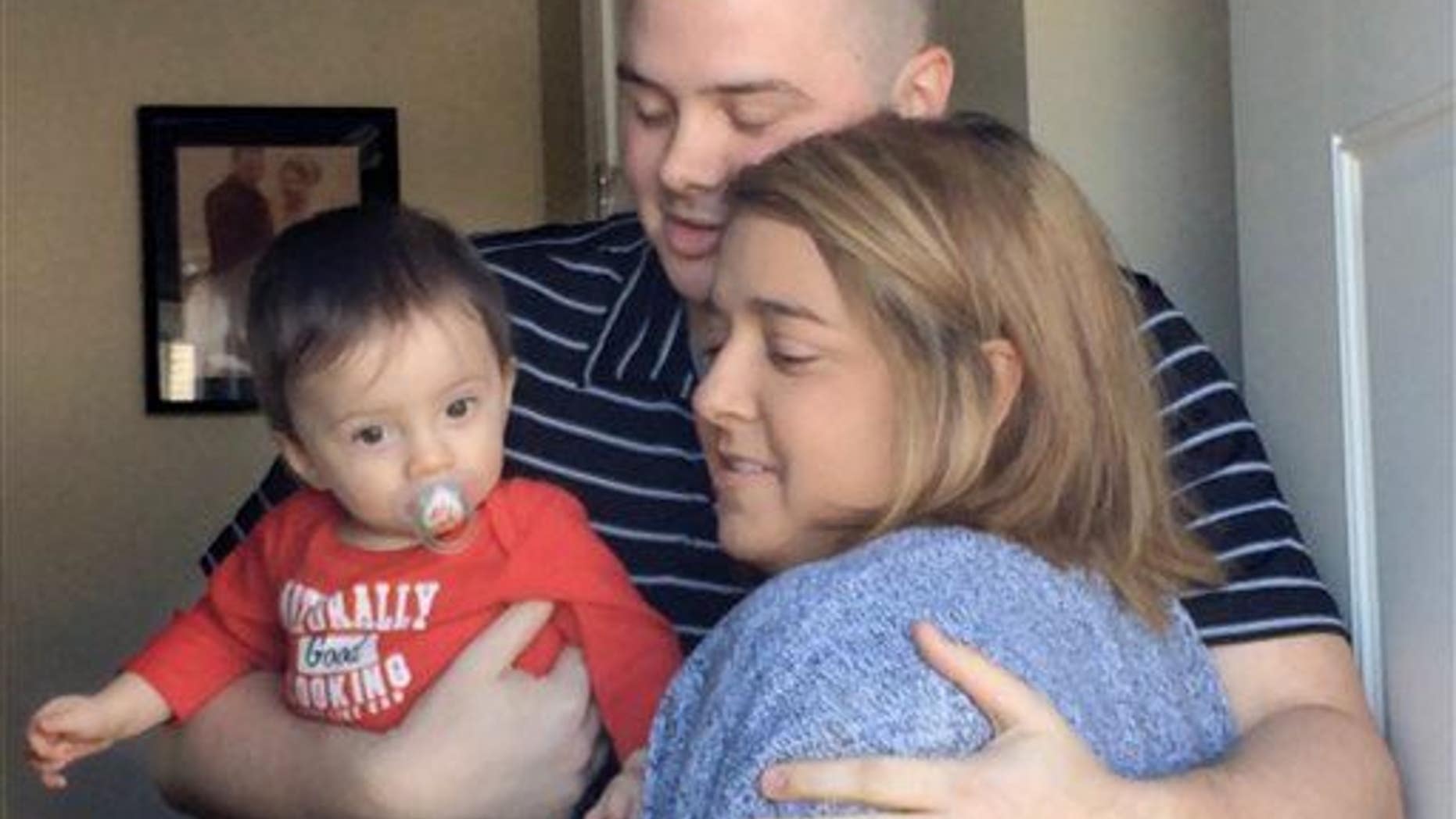 In this Tuesday, March 24, 2015 photo, Josh Dall-Leighton, holding son Christopher, hugs Christine Royles as they meet for the first time, at his home in Windham, Maine.