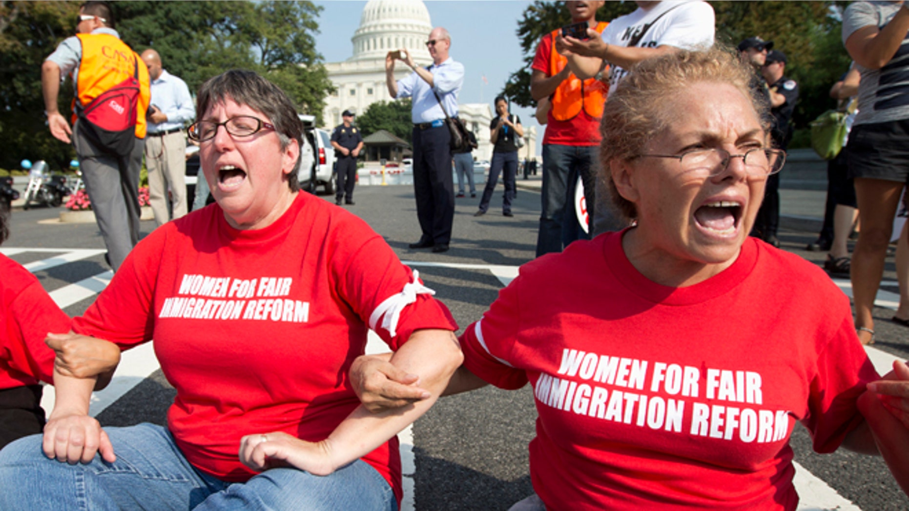 FILE - This Sept. 12, 2103 file photo shows women linking their arms and sit in a circle to block the intersection of Independence Avenue SE and New Jersey Avenue SE outside the House of Representatives on Capitol Hill in Washingto to protest Congress' inaction on comprehensive and inclusive immigration reform. They are all arrested soon after this images is taken. Latinos and immigration activists are warning of political peril for President Barack Obama and Democrats in the fall election if the president doesnt curb deportations and allow more immigrants to remain in the U.S. legally, including parents of children who were born in the U.S. or were brought to the country illegally. Many activists say Obama has been slow to grasp the anger and despair building within the Latino community. (AP Photo/Carolyn Kaster, File)