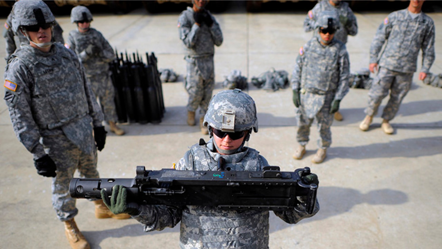 FILE - In this Feb. 23, 2014 file photo, an Army SPC hoists a 44-pound section of a 50 caliber machine gun onto a M1 A2 Abrams tank during a physical demands study at Ft. Stewart, Ga. (AP Photo/Stephen B. Morton, File)