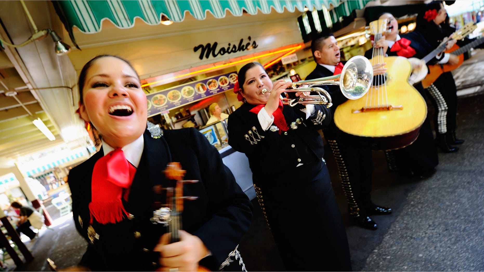 LOS ANGELES, CA - MAY 05: Judith Merillo (L) Esmeralda Garcia (2nd-L) Guillermo Nunez (C) Mariana Nanez and Ileana Garcia (R) members of the all-female strolling Mariachi band, Ellas Son, perform at Los Angeles Farmer Market during Cinco de Mayo festivities on May 5, 2011 in Los Angeles, California. Nunez was filling for the recovering injured female base player who was shot in the arm at a Mexican restaurant two weeks ago. Cinco de Mayo celebrates the 1862 Mexican victory over the French in the Battle of Puebla. (Photo by Kevork Djansezian/Getty Images)