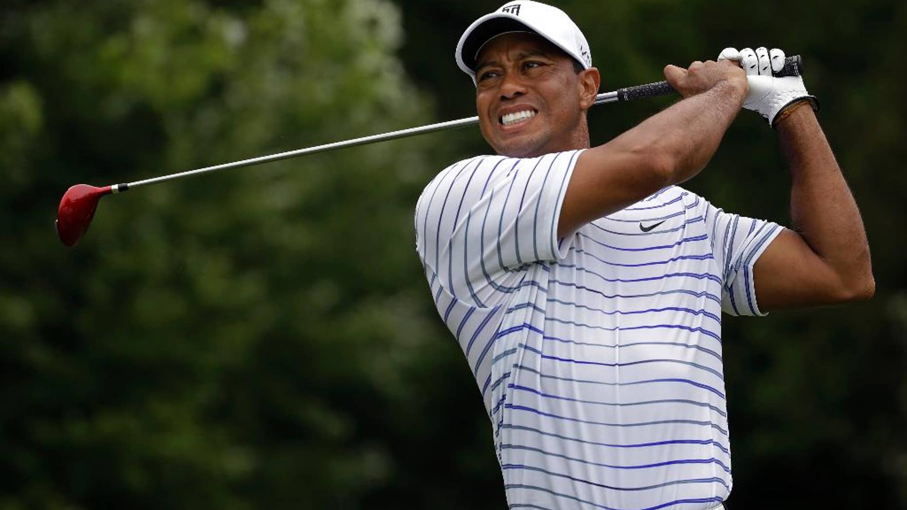 FILE - In this Friday, Aug. 8, 2014 file photo, Tiger Woods winces after tee shot on the sixth hole during the second round of the PGA Championship golf tournament at Valhalla Golf Club in Louisville, Ky. Tiger Woods removed himself from consideration for the Ryder Cup team Wednesday evening, Aug. 13, 2014 with a clear message that he is not healthy enough to play. (AP Photo/Jeff Roberson, File)