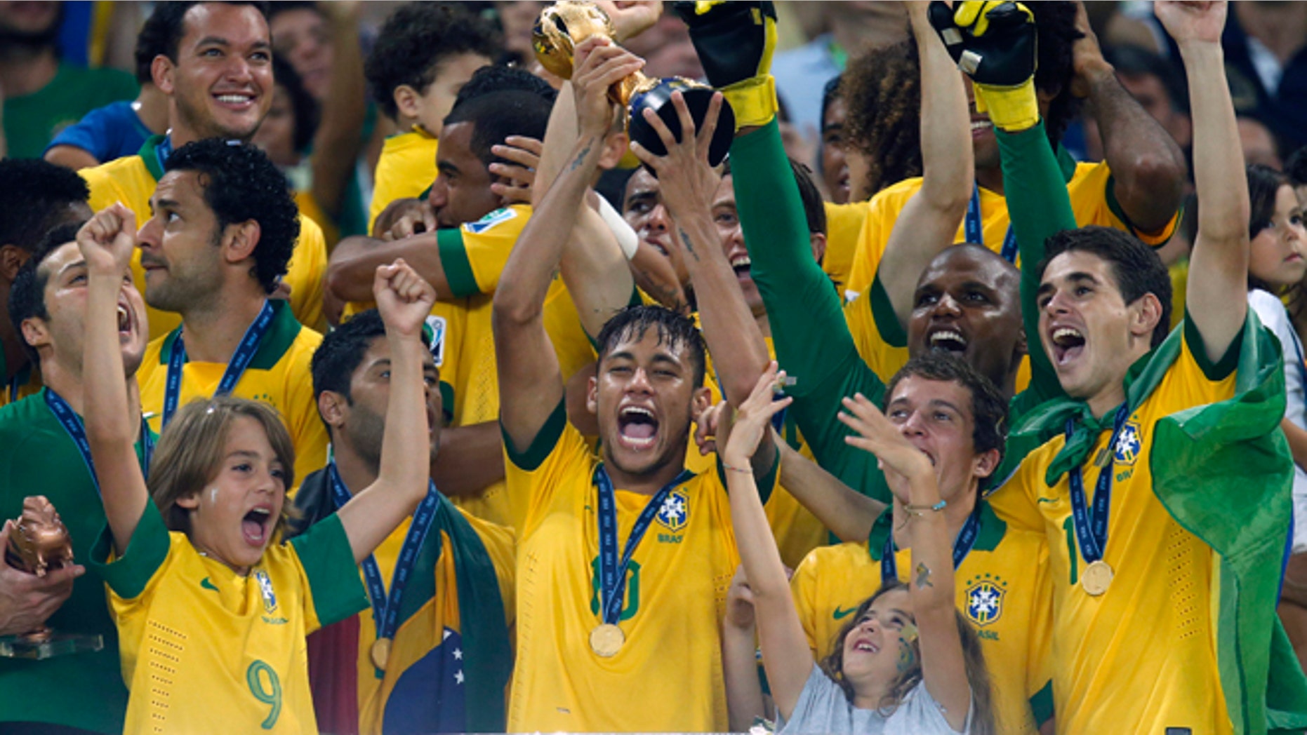 FILE - This Sunday, June 30, 2013 file photo shows Brazil's Neymar, center, as he lifts the trophy after winning the soccer Confederations Cup final between Brazil and Spain at the Maracana stadium in Rio de Janeiro, Brazil. (AP Photo/Victor Caivano, File)