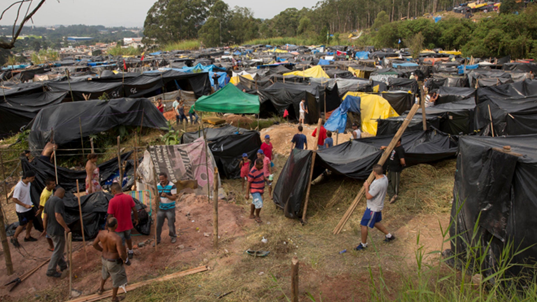 Members of the Homeless Workers Movement build their shacks within view of Itaquerao stadium in Sao Paulo, Brazil.