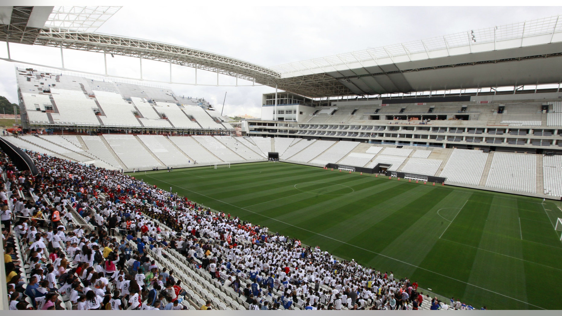 People stand in the bleachers during an infrastructure test at Arena de Sao Paulo Stadium, one of the venues for the 2014 World Cup.