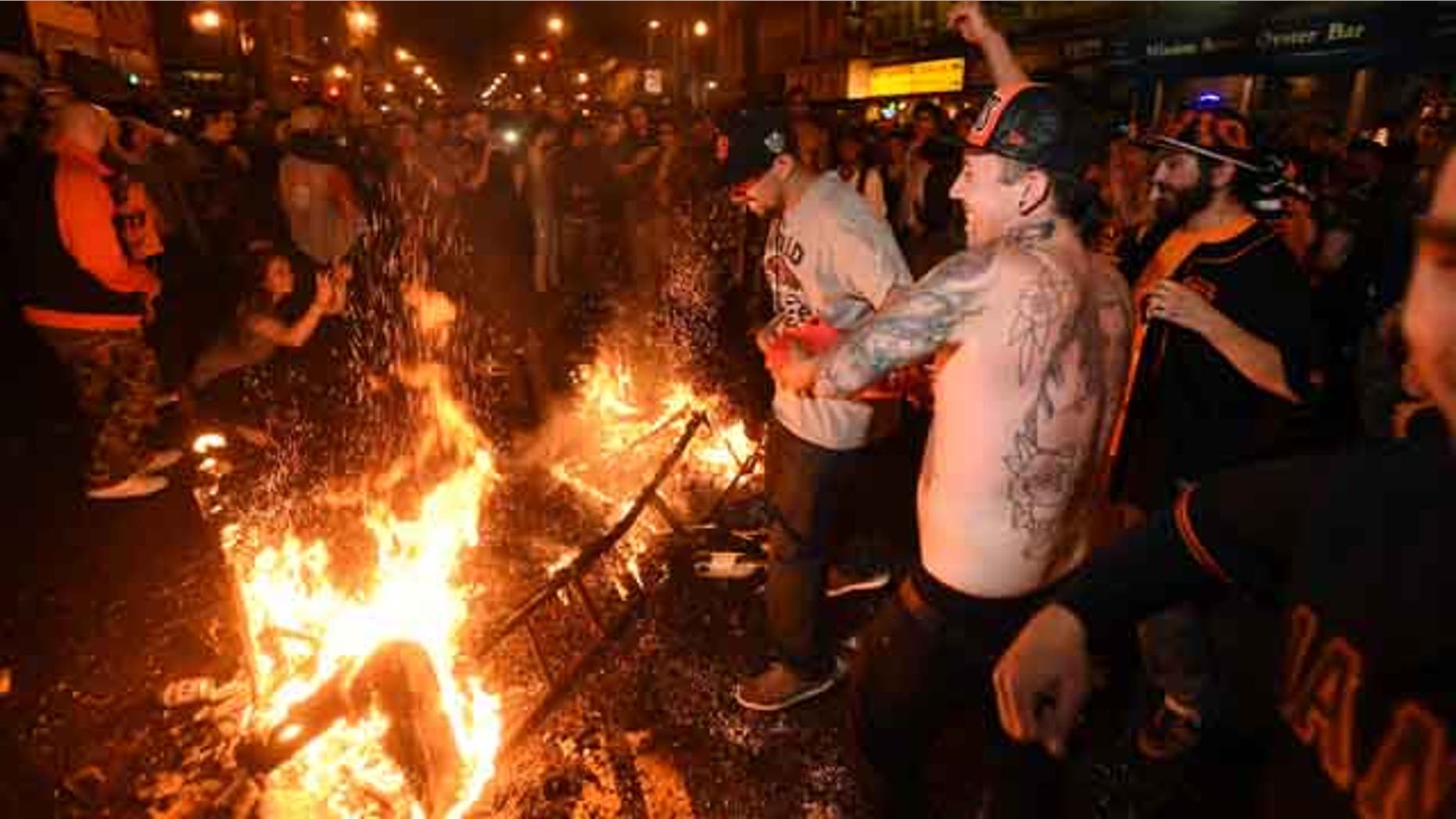 October 29, 2014: San Francisco Giants fans celebrate next to debris that has been set on fire in the Mission district after the San Francisco Giants beat the Kansas City Royals to win the World Series. (AP Photo/Noah Berger)