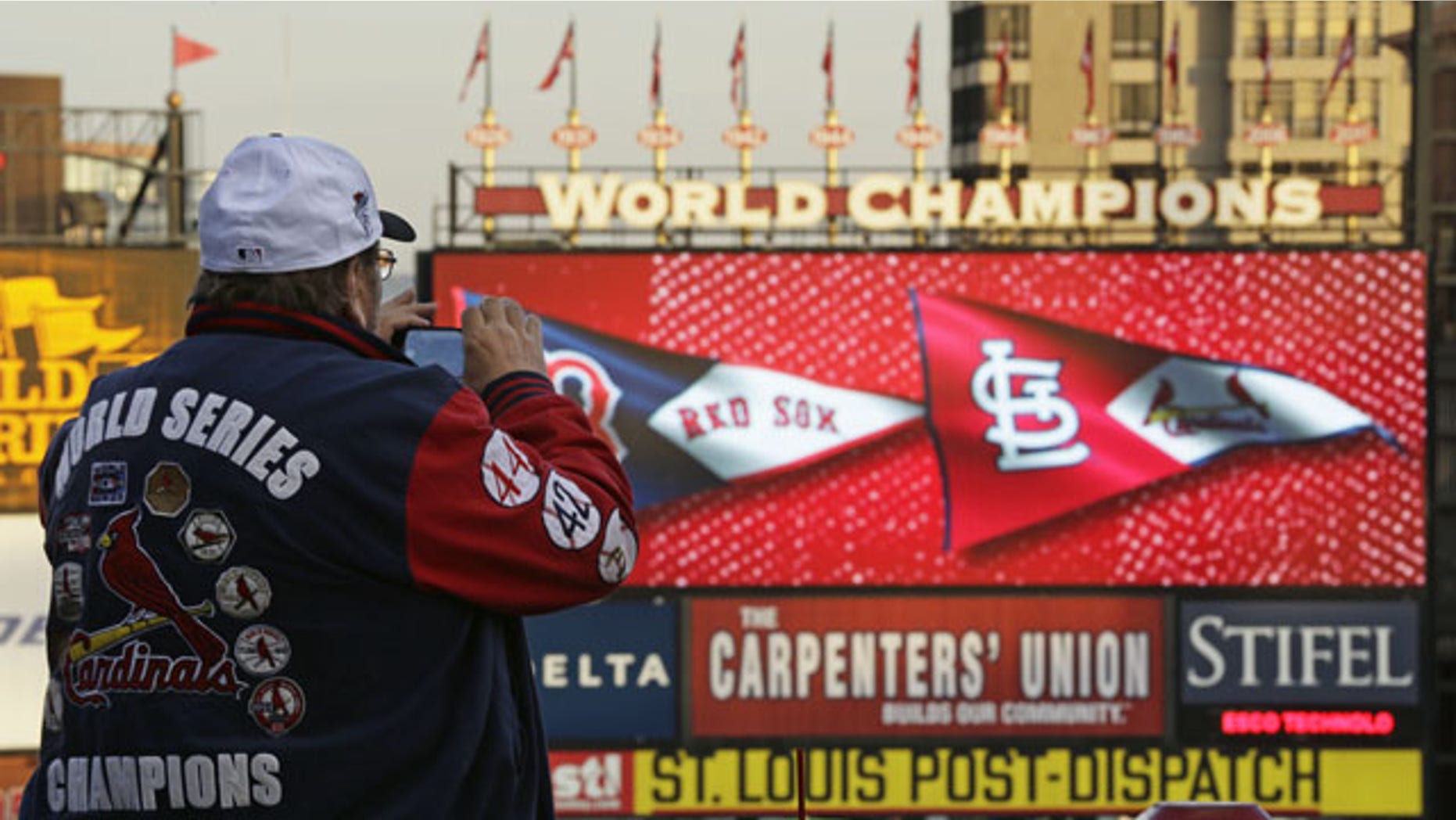 October 28, 2013: John Koenig takes a photo as players warm up for Game 5 of baseball's World Series between the Boston Red Sox and the St. Louis Cardinals in St. Louis. (AP Photo/Charlie Riedel)