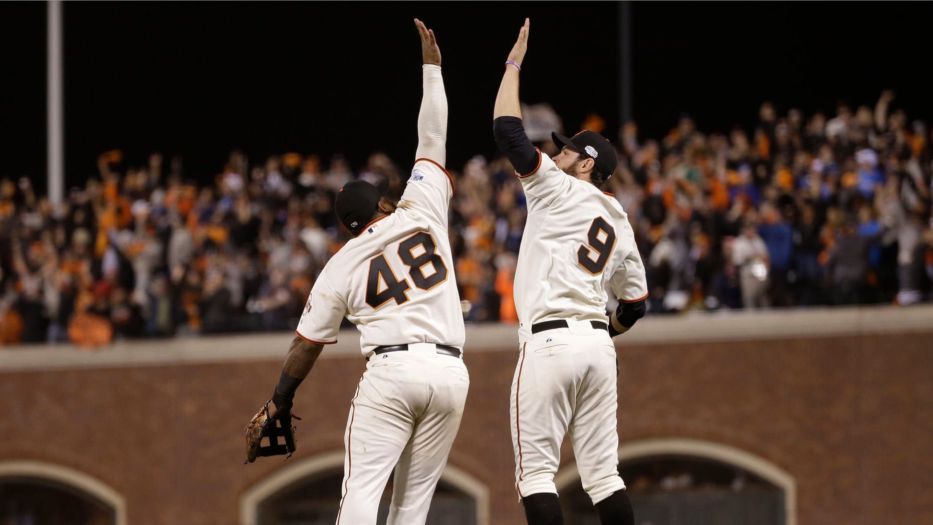 San Francisco Giants Pablo Sandoval, left, leaps up to high five Brandon Belt after defeating the Kansas City Royals 11-4 in Game 4 of baseball's World Series Saturday, Oct. 25, 2014, in San Francisco. (AP Photo/Matt Slocum)