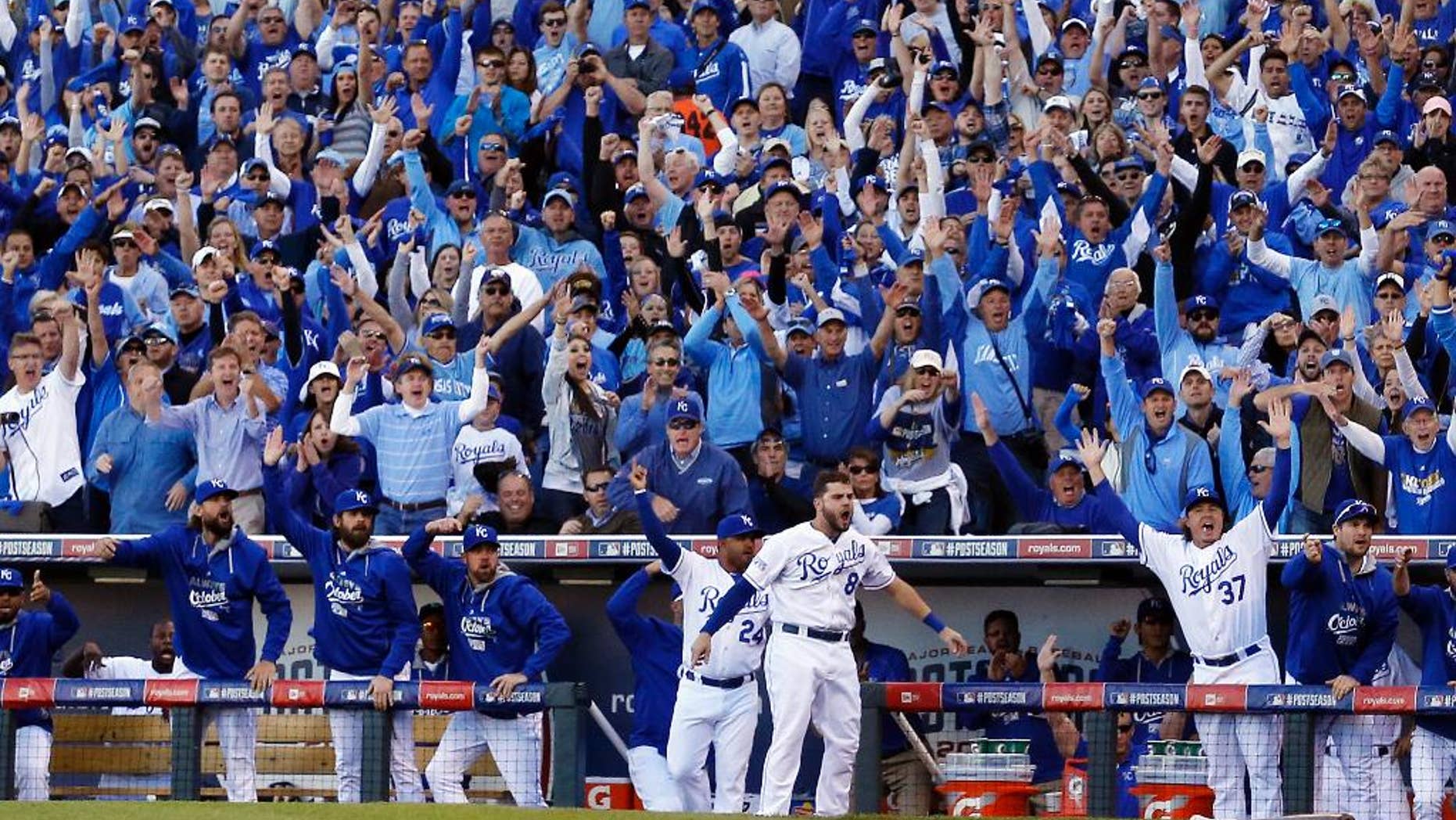 FILE - In this Oct. 15, 2014, file photo, Kansas City Royals players and fans celebrate after Alcides Escobar scores during the first inning of Game 4 of the American League baseball championship series against the Baltimore Orioles in Kansas City, Mo. Kansas City fans have come a long, long way from spring training when many hated the young team without a lot of star appeal. The city is now caught up in a love affair with the Royals, and the players are reciprocating, reminding many folks of a bygone era in professional sports. (AP Photo/Matt Slocum, File)
