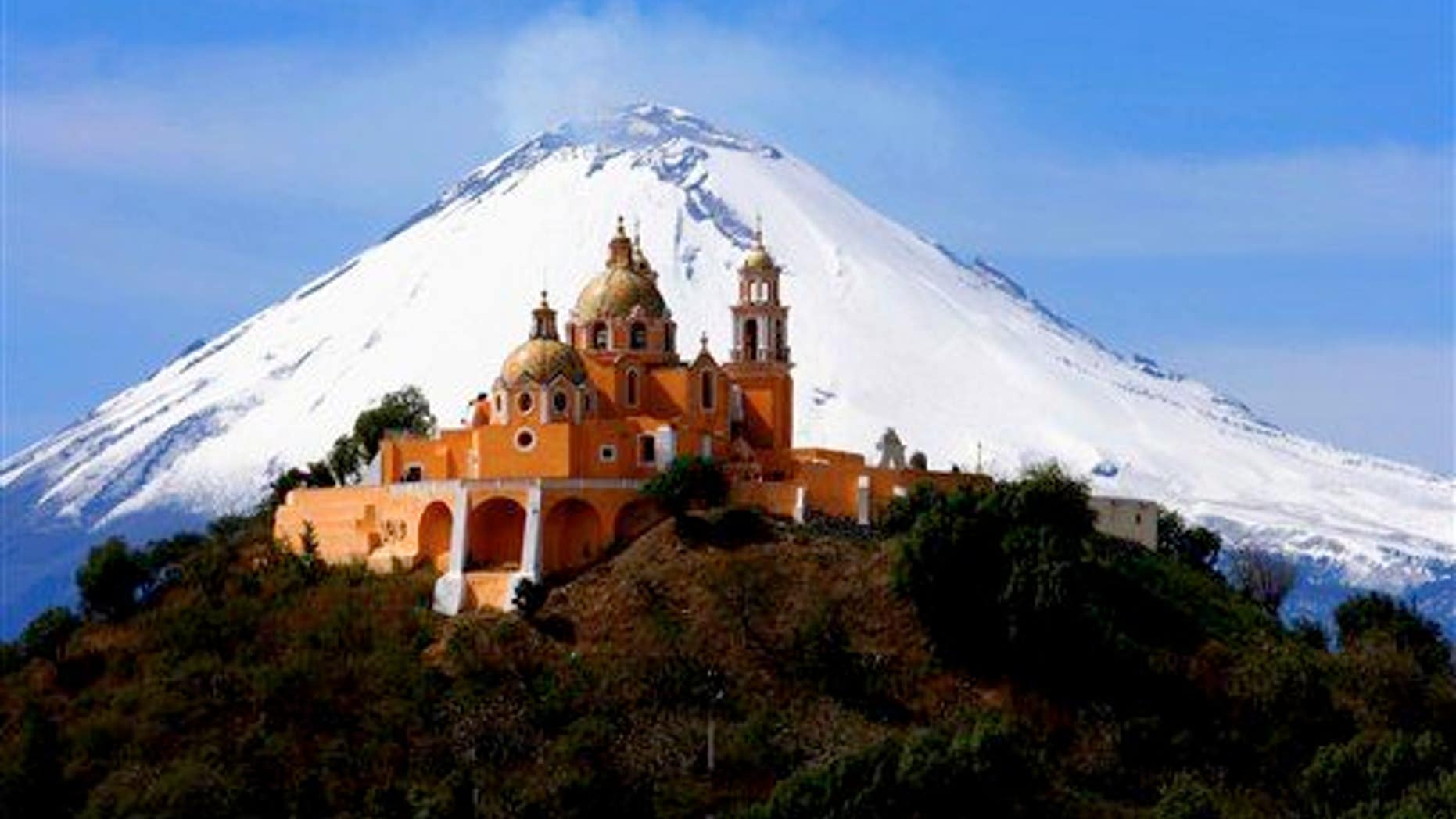 In this Nov. 21, 2006 file photo, the Our Lady of Remedios church is backdropped by the snowcapped volcano Popocatepetl, in Cholula, in the Mexican state of Puebla. It's perched atop an ancient pyramid.