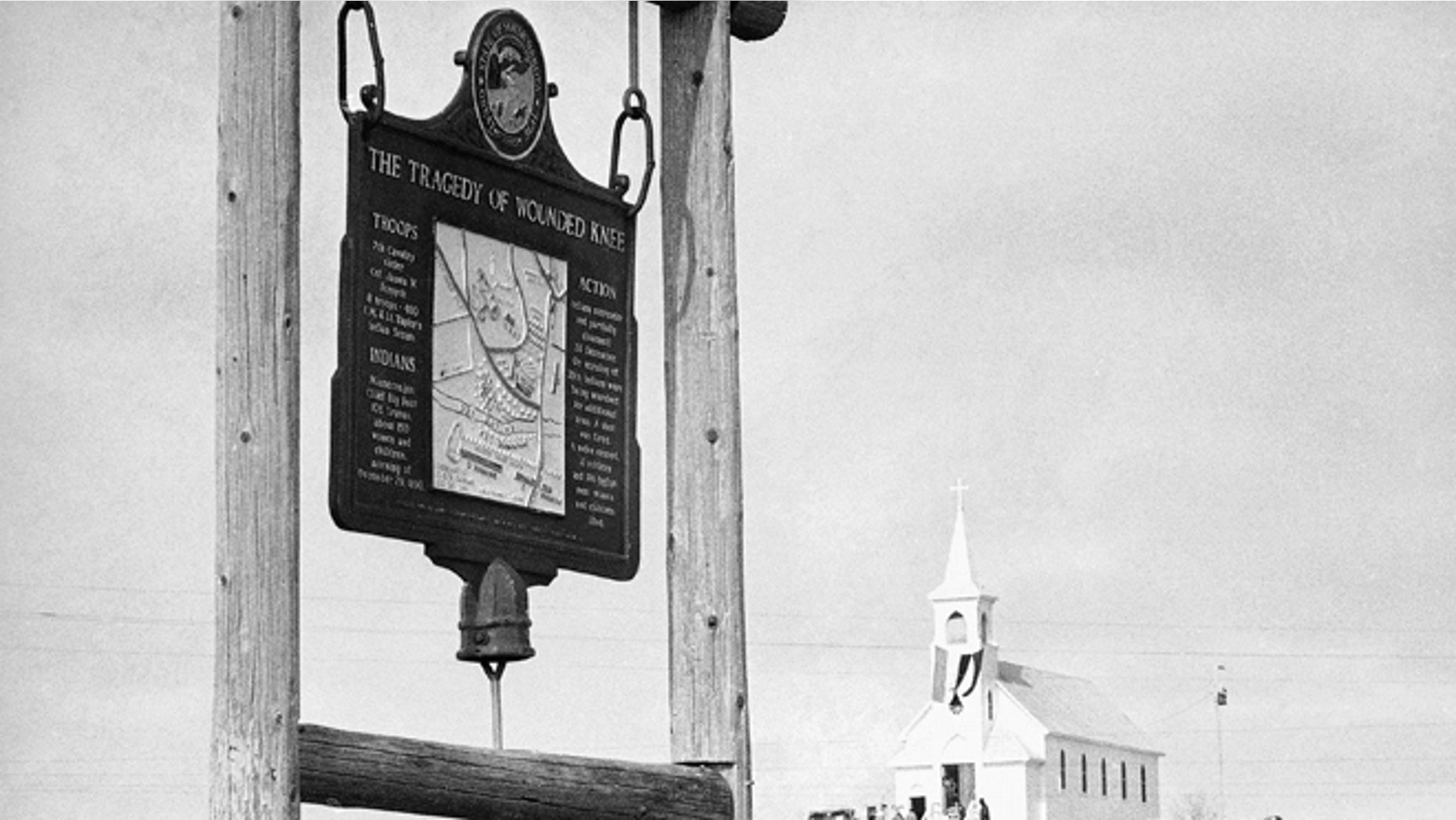 This undated file photo shows the historical marker commemorating the Wounded Knee Massacre of 1890 on the road near the Sacred Heart Catholic Church in Wounded Knee, S.D.