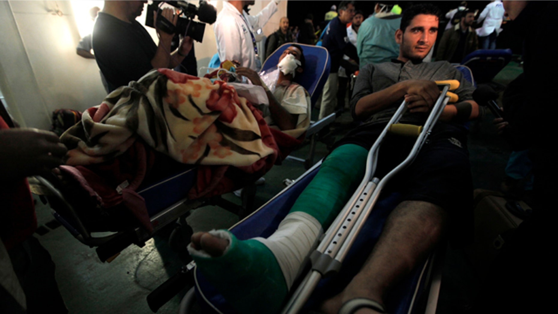 April 18: Two injured Libyan men are moved toward a waiting ambulance outside a boat that evacuated foreign refugees and injured residents, who were trapped for weeks by the fighting in Misrata, and docked at the port of Benghazi, Libya.