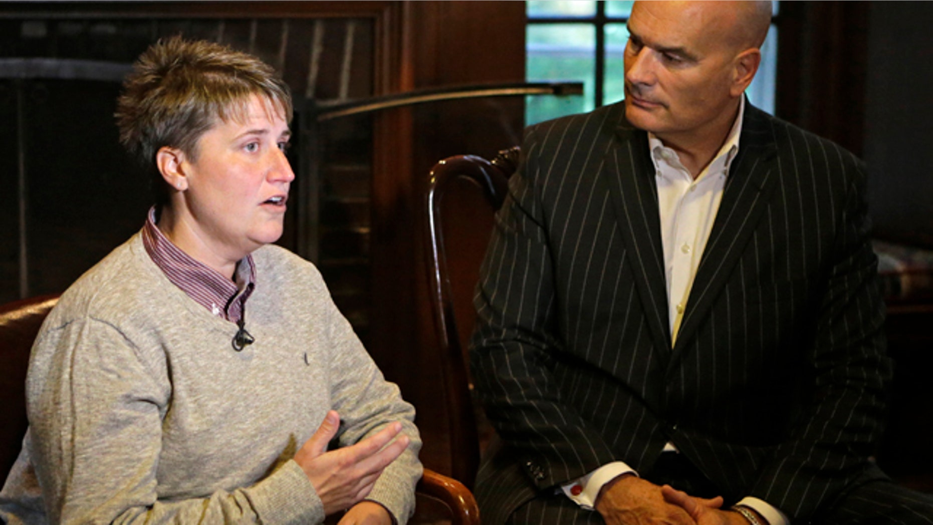Jennifer Cramblett is interviewed at the home of her attorney, Tim Misny, right, in Waite Hill, Ohio Wednesday, Oct. 1, 2014. Cramblett has sued a Chicago-area sperm bank after she became pregnant with sperm donated by a black man instead of a white man as she'd intended. (AP Photo/Mark Duncan)