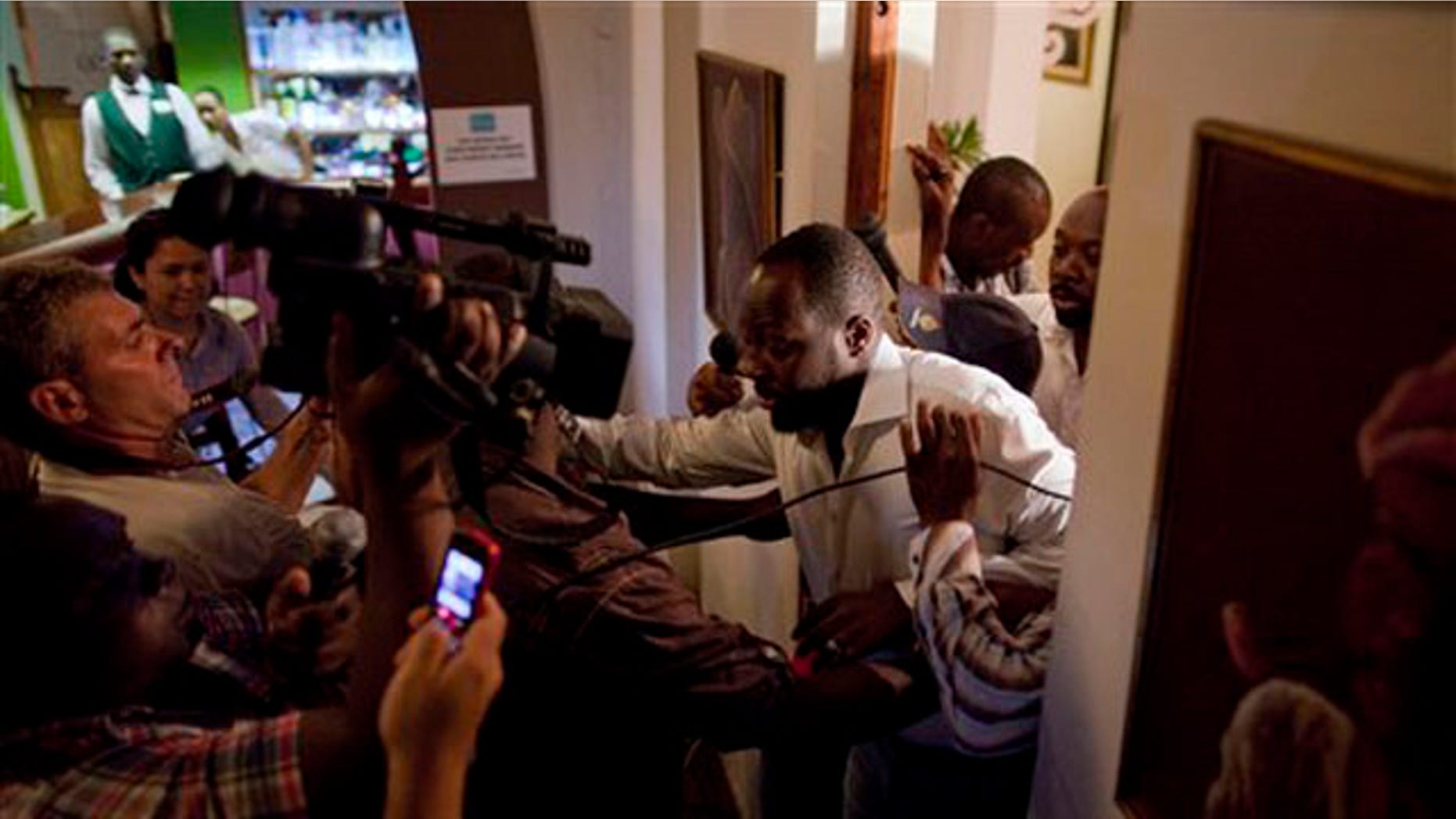 Aug. 20: Haitian-born singer and presidential candidate Wyclef Jean, right, exits a hotel room after Haiti's Electoral Council rejected his presidential candidacy in Port-au-Prince, Haiti, on Friday.