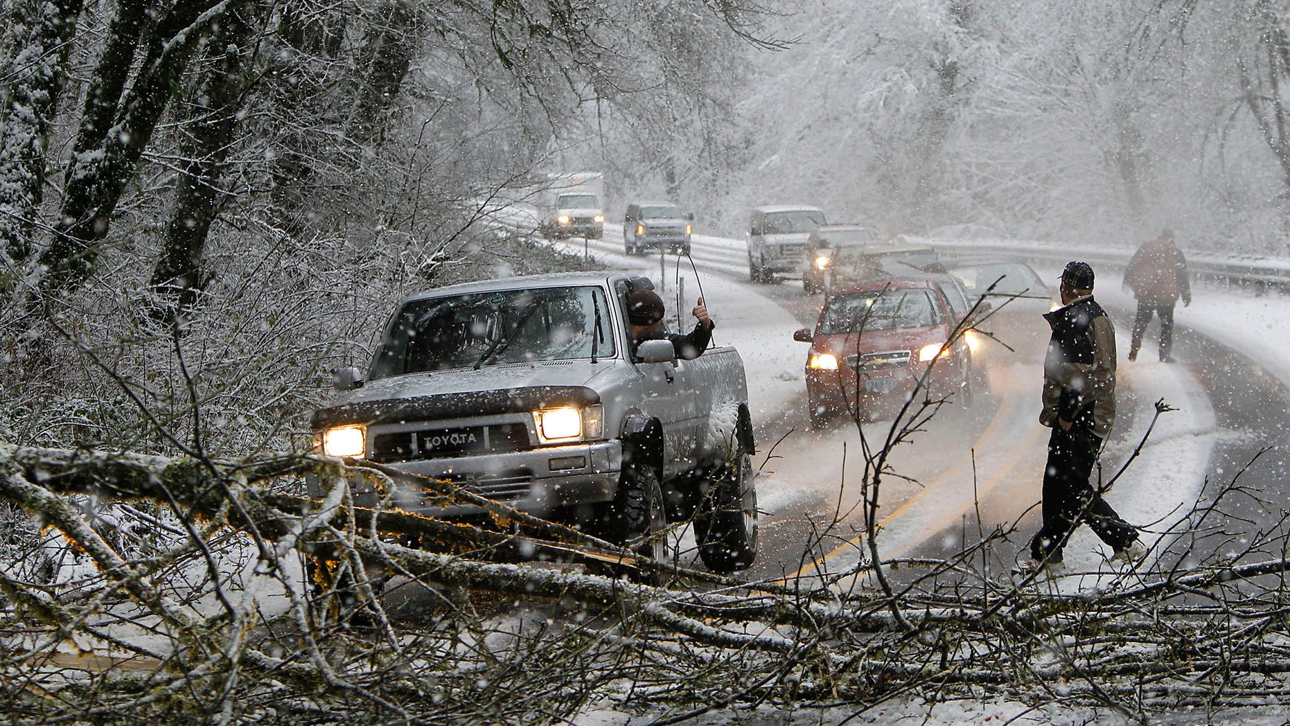 Dec. 20, 2012: A motorist in a pickup truck pulls a tree out of the way about five miles East of Mapleton, Ore. as heavy snow in the Oregon Coast Range caused trees to fall across Highway 126 Thursday morning.