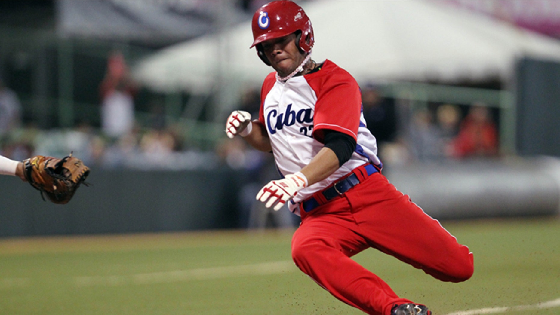 FILE - In this Feb. 7, 2015 file photo, Cubas Yadiel Hernández slides safe at the home plate during a Caribbean Series baseball semifinal game against Venezuela in San Juan, Puerto Rico. Cuba is confirming that two baseball players, including Hernández, have defected while in the United States for a series of friendly games against U.S. collegians. (AP Photo/Ricardo Arduengo, File)