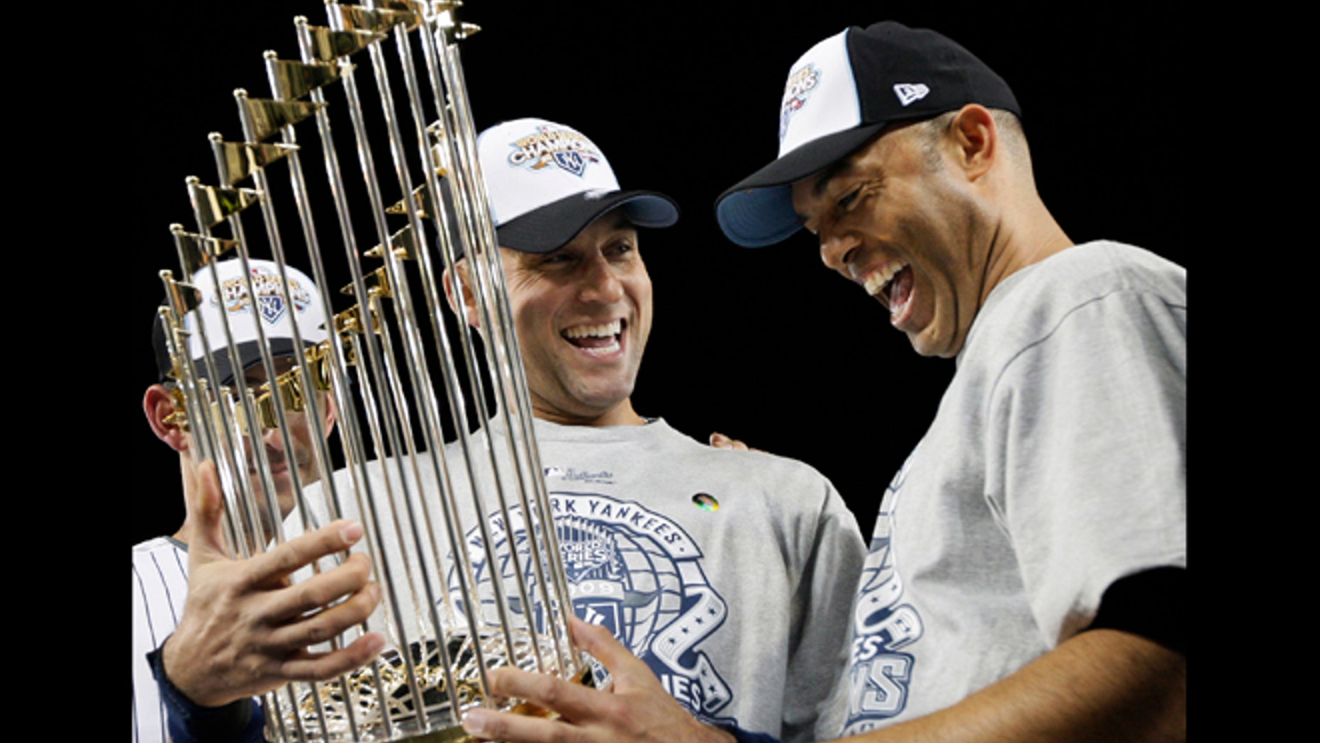 FILE - In this Nov. 4, 2009, file photo, New York Yankees' Derek Jeter, left, and Mariano Rivera look at the championship trophy after winning the Major League Baseball World Series against the Philadelphia Phillies, in New York. Jeter says he will retire after this season "with absolutely no regrets," ending one of the greatest careers in the history of baseball's most storied franchise.The 39-year-old New York captain posted a long letter on his Facebook page Wednesday, Feb. 12, 2014, saying that 2014 will be his final year. (AP Photo/David J. Phillip, File)