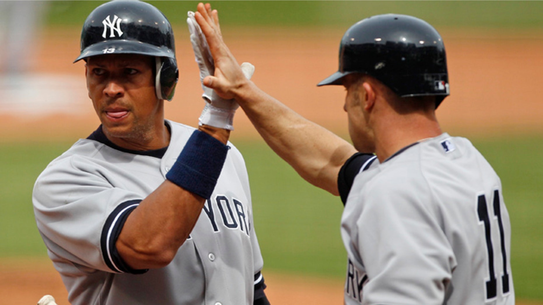 April 8, 2011: New York Yankees Alex Rodriguez, left, celebrates with teammate Brett Gardner after being driven home on a double by Robinson Cano during the first inning of a baseball game at Fenway Park in Boston.