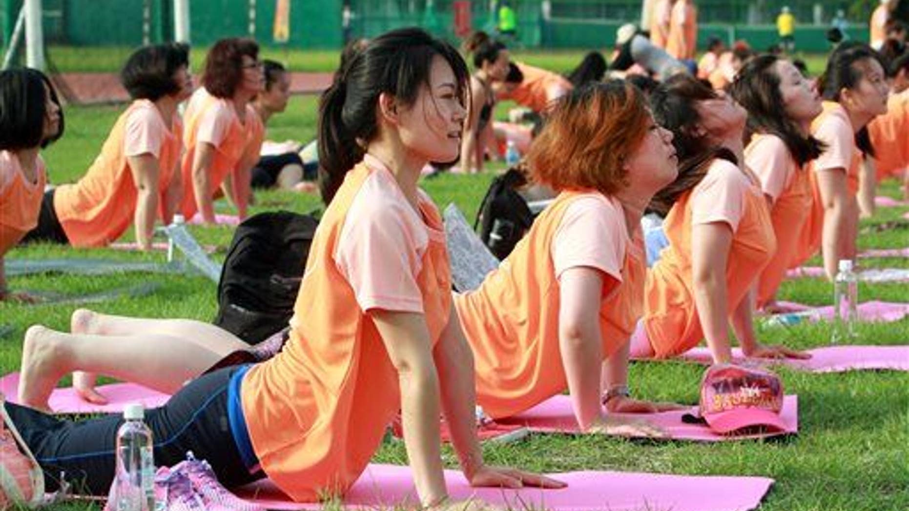 Taiwanese perform yoga poses at the start of International Yoga Day in Taipei, Taiwan, June 21, 2015.
