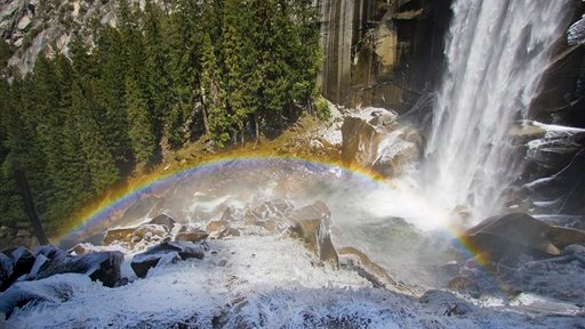 FILE - In this April 16, 2009 file photo, ice forms around a rainbow at the base of Vernal Falls on the Mist Trail in Yosemite National Park. Search and rescue rangers at Yosemite National Park were scouring an area below the popular waterfall Tuesday afternoon, July 19, 2011, after witnesses reported seeing at least one hiker being swept over the falls. (AP Photo/The Tahoe Tribune, Jonah M. Kessel)