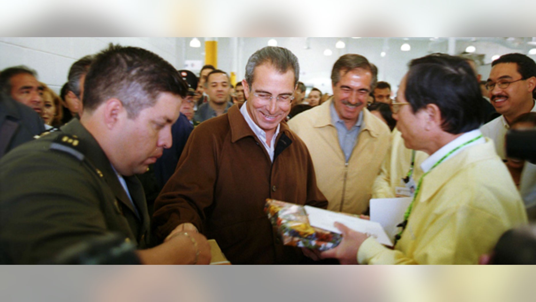 Mexico's president Ernesto Zedillo (in brown jacket) and Chihuahua state governor, Patricio Martinez, (to right) are given gifts as they leave the new Acer maquiladora in Ciudad Juarez, Mexico February 23, 2000. (Photo by Joe Raedle)