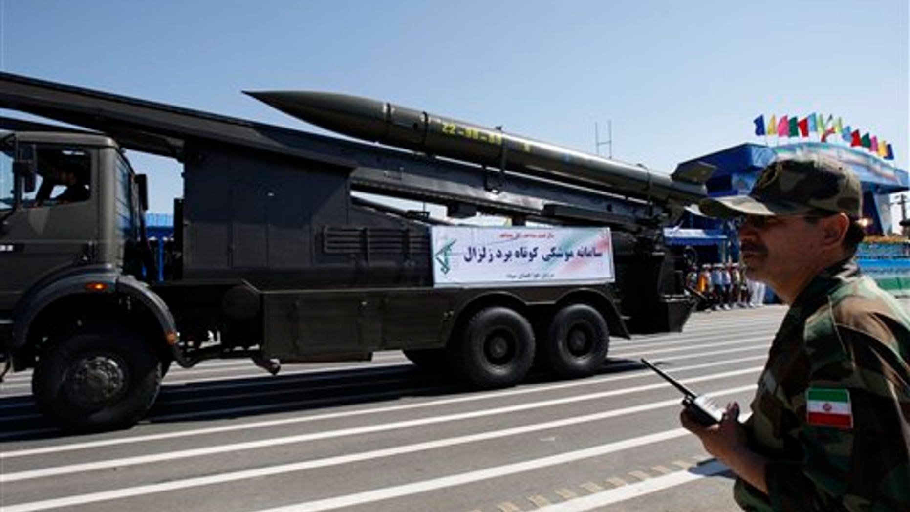 A Zelzal, or earthquake, missile is displayed by the Iranian Revolutionary Guard, as a member of the Guard stands at right, during a military parade marking the 30th anniversary of outset of the 1980-88 Iran-Iraq war, in front of the mausoleum of the late revolutionary founder Ayatollah Khomeini, just outside Tehran, Iran, Wednesday, Sept. 22, 2010.