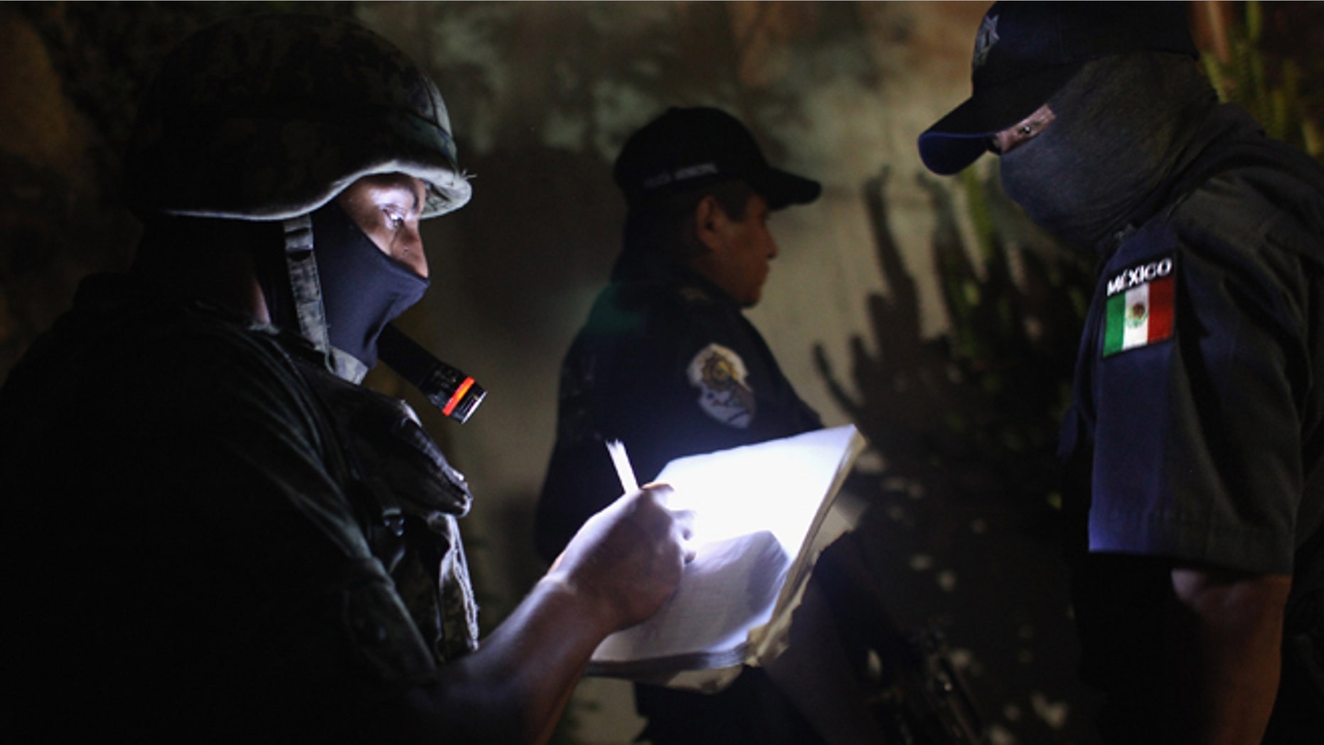 ACAPULCO, MEXICO - MARCH 03: A Mexican soldier takes notes at a suspected drug-related murder site late March 3, 2012 in Acapulco, Mexico. A forensics team excavated five corpses from the floor of an abandoned house. Officials said the five victims were apparently buried alive in concrete. Drug violence has surged in the coastal resort in the last year, making Acapulco the second most deadly city in Mexico after Juarez. One of Mexico's top tourist destinations, Acapulco has suffered a drop in business, especially from foreign tourists, due to the violence. Toursim accounts for about 70 percent of the economy of Acapulco's state of Guerrero and 9 percent of Mexico's economy. (Photo by John Moore/Getty Images)