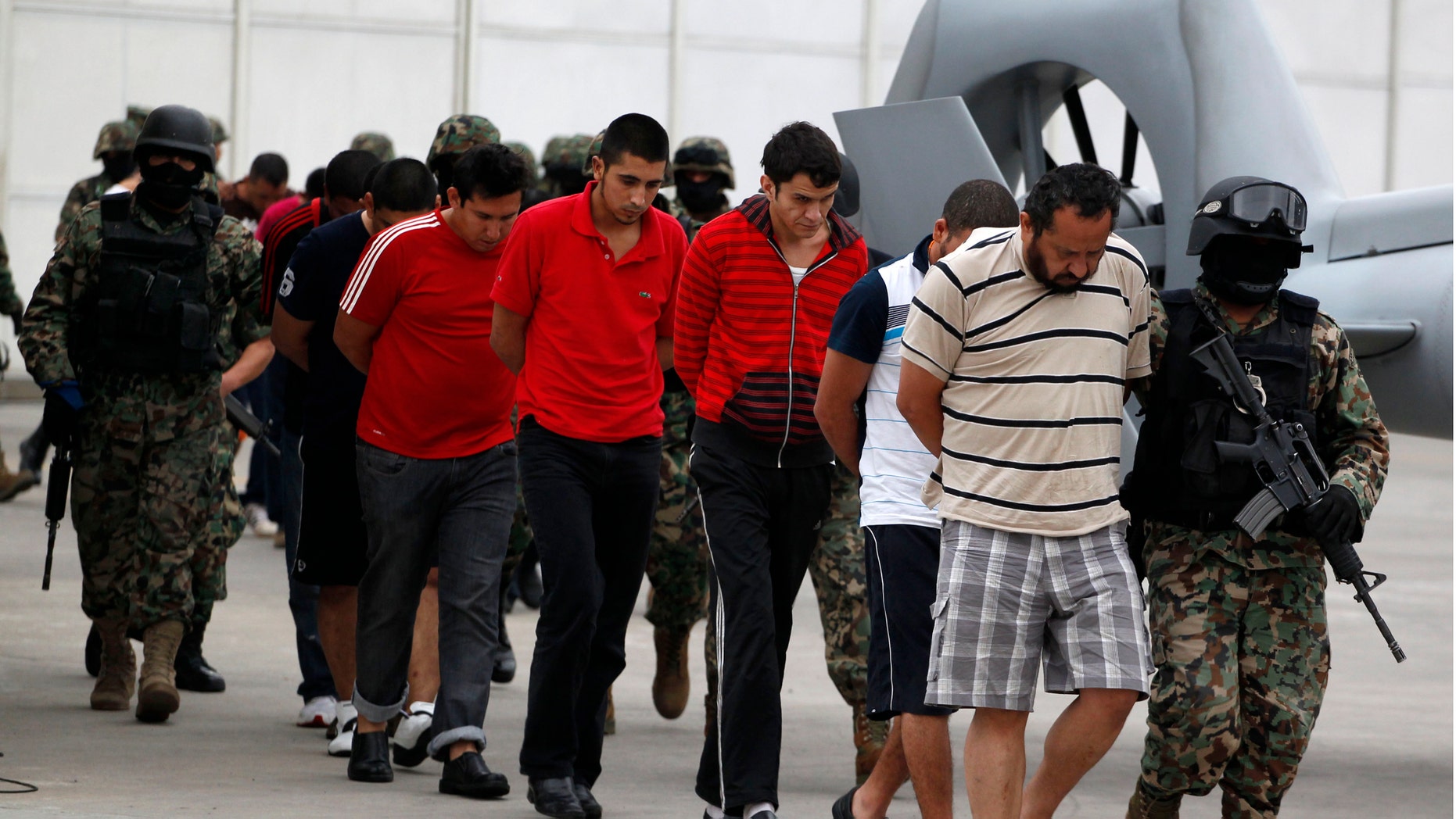 Alfredo Carmona alias "el Capi," leader of the New Generation gang, right, is escorted along with other suspects of the New Generation gang, which dubbed itself "Mata Zetas," or "Zetas Killers," by marines as they are presented to the press in Mexico City, Friday Oct. 7, 2011. The relatively new drug gang is responsible for killing at least 67 people whose bodies were found over the course of a couple of weeks in the Gulf coast state of Veracruz, according to authorities. (AP Photo/Eduardo Verdugo)