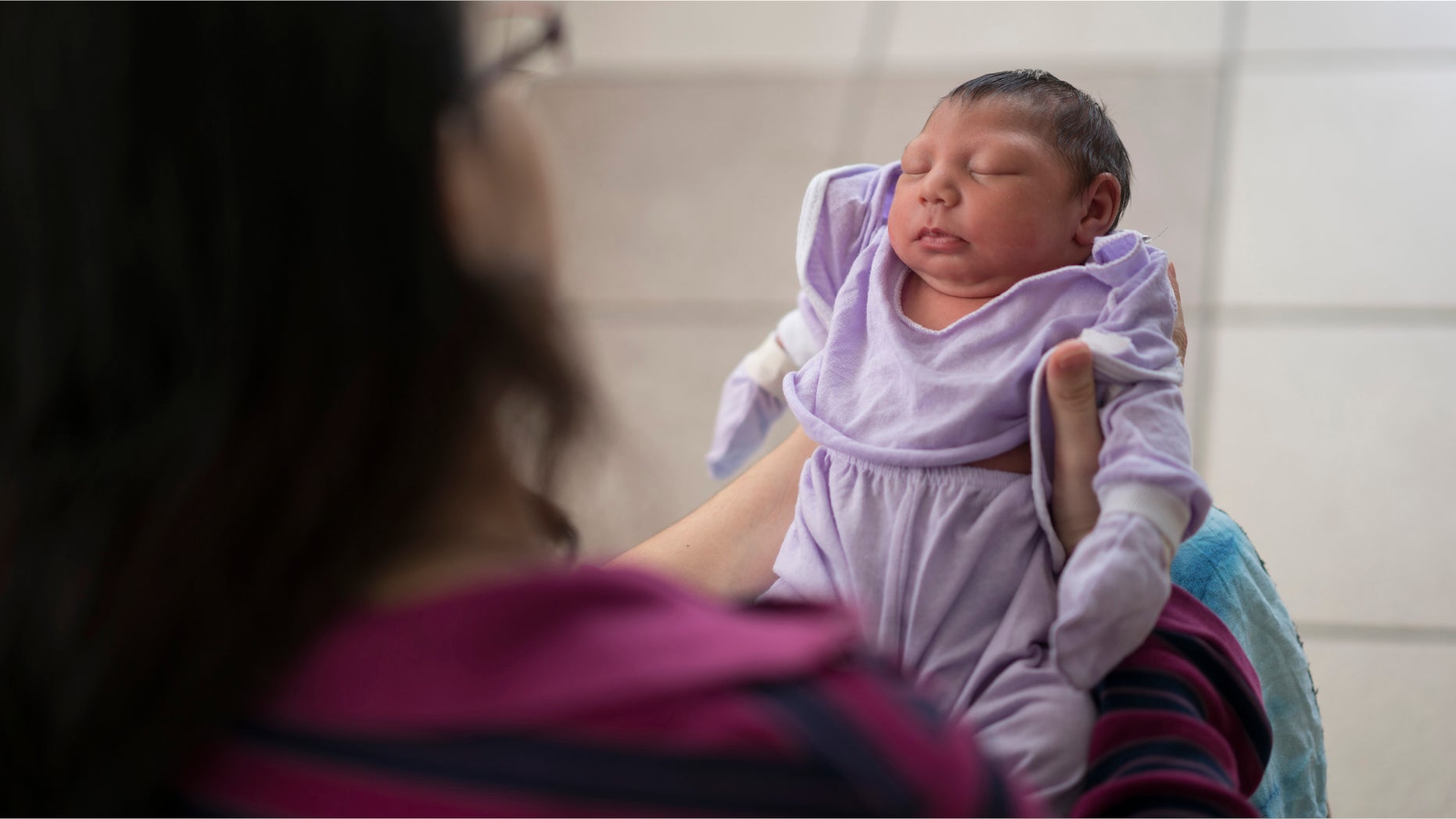 Cassiana Severino holds her daughter Melisa Vitoria, born with microcephaly at the IMIP hospital in Recife, Pernambuco state, Brazil, Wednesday, Feb. 3, 2016. The Zika virus is spread by the Aedes aegypti mosquito, which is well-adapted to humans, thrives in people's homes and can breed in even a bottle cap's-worth of stagnant water. The Zika virus is suspected to cause microcephaly in newborn children. (AP Photo/Felipe Dana)