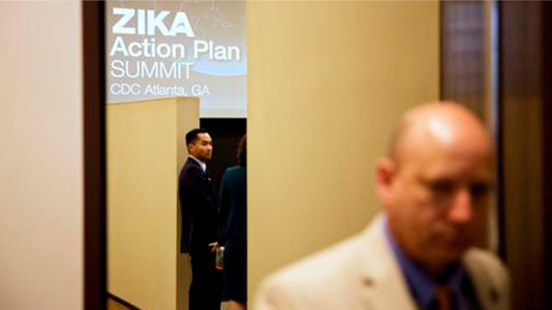 A graphic is displayed on a screen as attendees wait for a seminar to begin at a one-day Zika summit at the Centers for Disease Control and Prevention Friday, April 1, 2016, in Atlanta. The government is urging health officials from around the country to prepare for potential outbreaks of the mosquito-borne virus in the U.S. (AP Photo/David Goldman)
