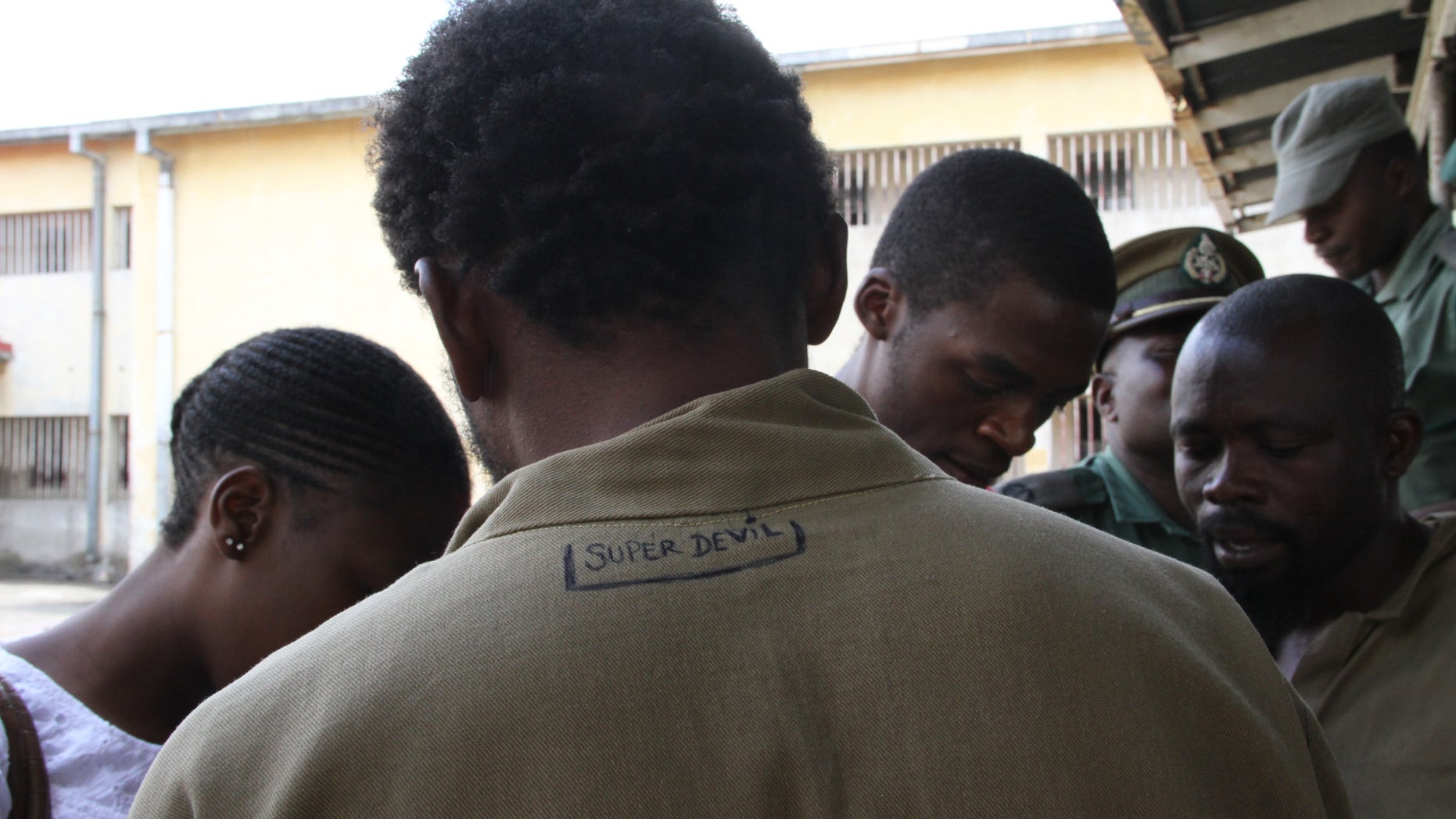 February, 22, 2013 - George Renene Longange, 41, shows the back of his prison clothing with the words, "Super Devil" inscribed, as he talks to the media at Harare Remand Prison, in Harare, Zimbabwe.