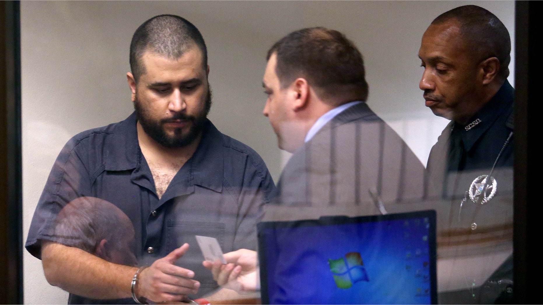 George Zimmerman, left, acquitted in the high-profile killing of unarmed black teenager Trayvon Martin, leaves court court along with defense counsel Daniel Megaro Tuesday, Nov. 19, 2013, in Sanford, Fla., after Zimmerman's hearing on charges including aggravated assault stemming from a fight with his girlfriend. (AP Photo/Orlando Sentinel, Joe Burbank, Pool)