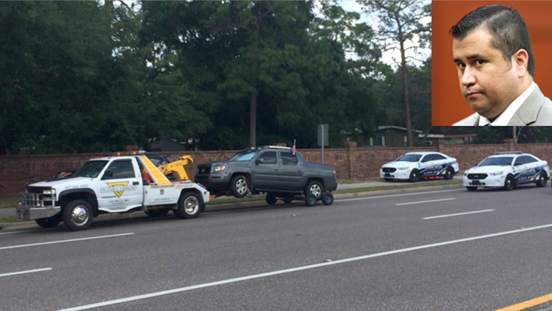 A truck is towed at the scene of a shooting involving George Zimmerman, Monday, May 11, 2015, near Trailhead Park in Lake Mary, Fla. The man who called 911 to report he was involved in the shooting appears to be Matthew Apperson, the same person allegedly involved in a road rage incident Zimmerman last year. (Jeff Weiner/Orlando Sentinel via AP)