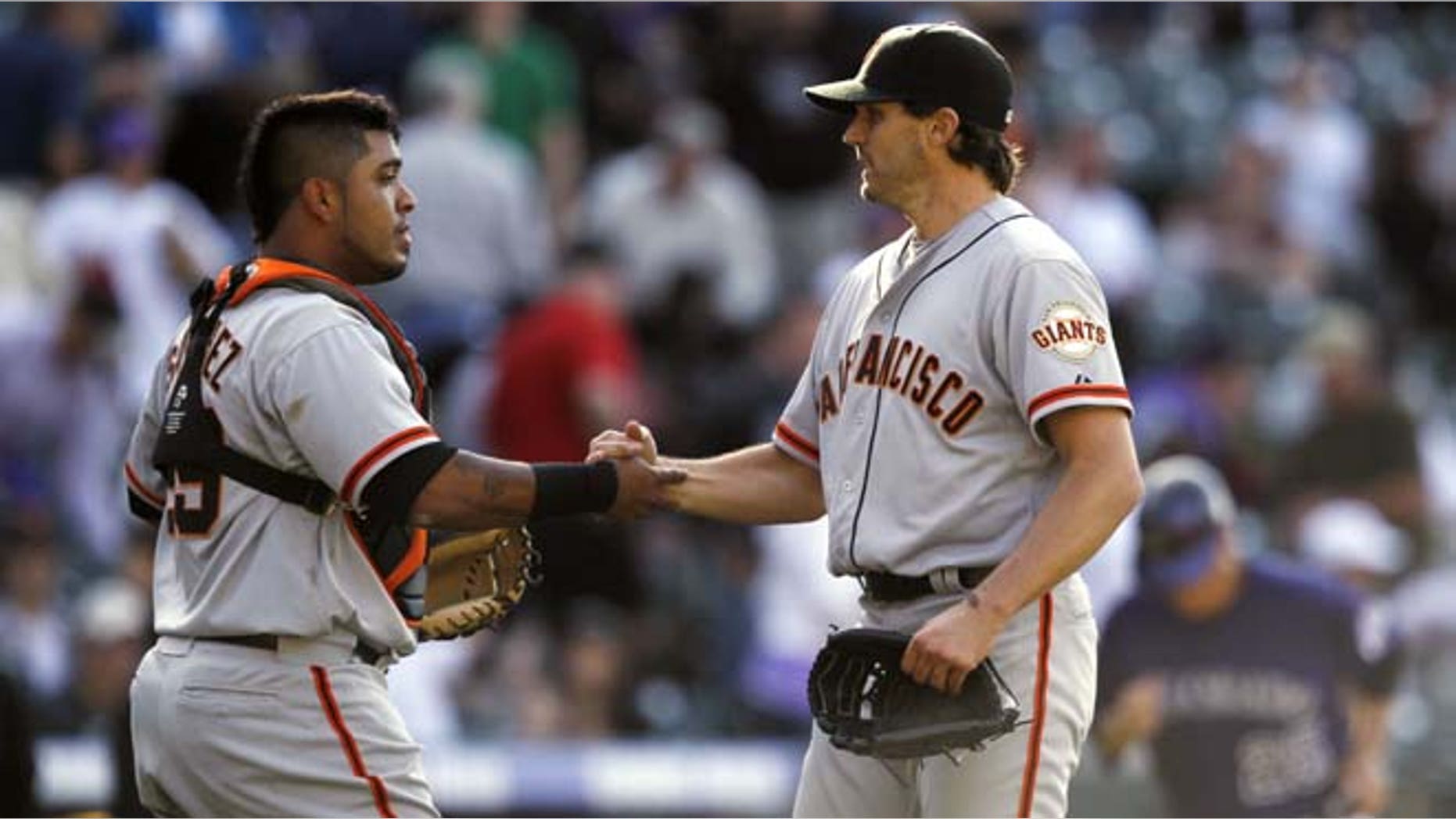 San Francisco Giants catcher Hector Sanchez, left, congratulates starting pitcher Barry Zito after he notched the final out in the ninth inning for a shut out in the Giants' 7-0 victory over the Colorado Rockies in a baseball game in Denver on Monday, April 9, 2012.