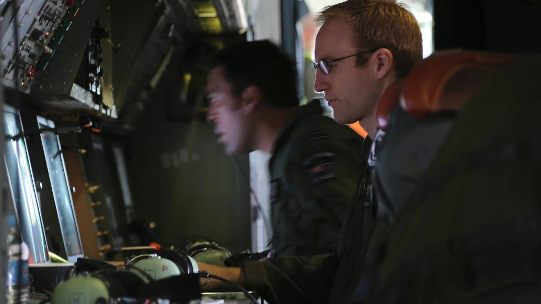 Flight Lieutenant Stephen Graham monitors a TAC station onboard a Royal New Zealand Air Force P3 Orion during search operations for wreckage and debris of missing Malaysia Airlines Flight MH370 in the southern Indian Ocean, near the coast of Western Australia, Friday, April 4, 2014. Ten military planes, four civil jets and nine ships will assist in the search today of 217,000 square kilometers, 1700kms north west of Perth.(AP Photo/Nick Perry/Pool)