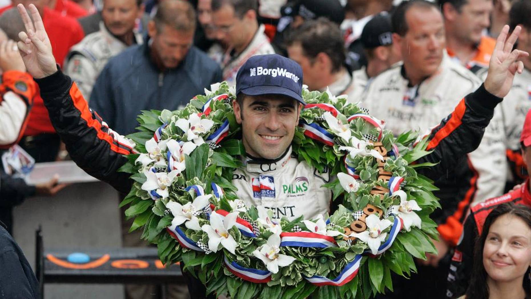 FILE - In this May 27, 2007, file photo, Dario Franchitti, of Scotland, gestures after his win in the Indianapolis 500 auto race at Indianapolis Motor Speedway in Indianapolis, Ind. At lower right is his wife, actress Ashley Judd. (AP Photo/Darron Cummings, File)
