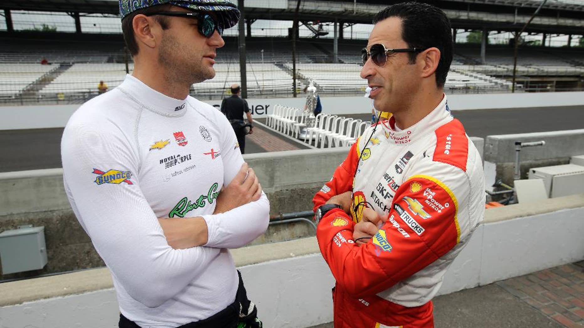 Helio Castroneves, of Brazil, right, talks with Townsend Bell before the start of practice for the Indianapolis 500 auto race at Indianapolis Motor Speedway in Indianapolis, Monday, May 18, 2015. (AP Photo/Darron Cummings)