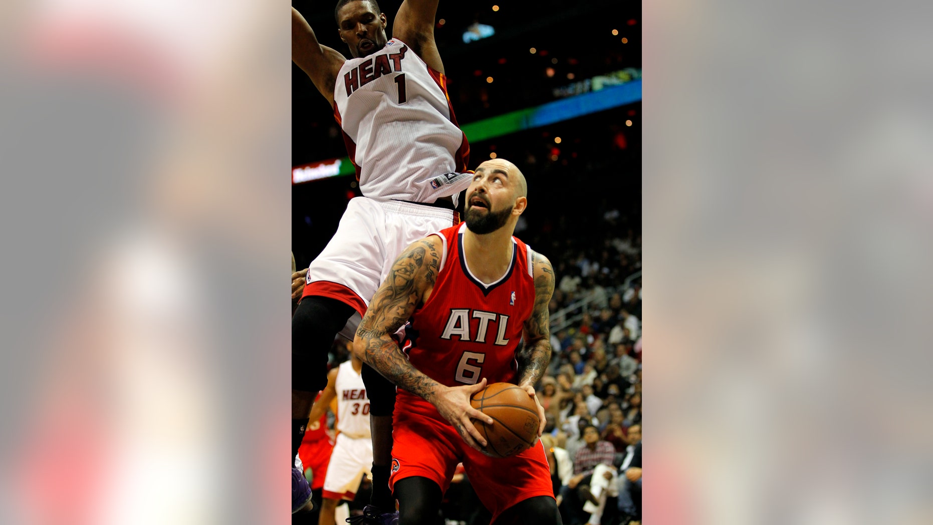 Atlanta Hawks center Pero Antic (6) looks to shoot as he is defended by Miami Heat center Chris Bosh (1) in the fourth period of an NBA basketball game in Atlanta, Monday, Jan. 20, 2014. The Hawks won 121-114. (AP Photo/Todd Kirkland)
