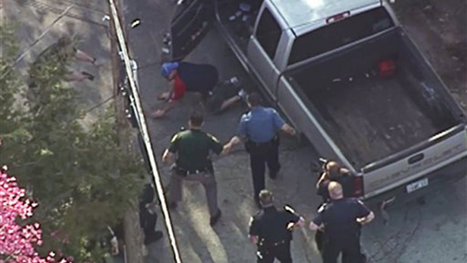 This aerial image made from a helicopter video provided by WHDH shows Richard Simone kneeling and putting his hands on the ground after a high-speed police pursuit in Nashua, N.H., Wednesday, May 11, 2016.
