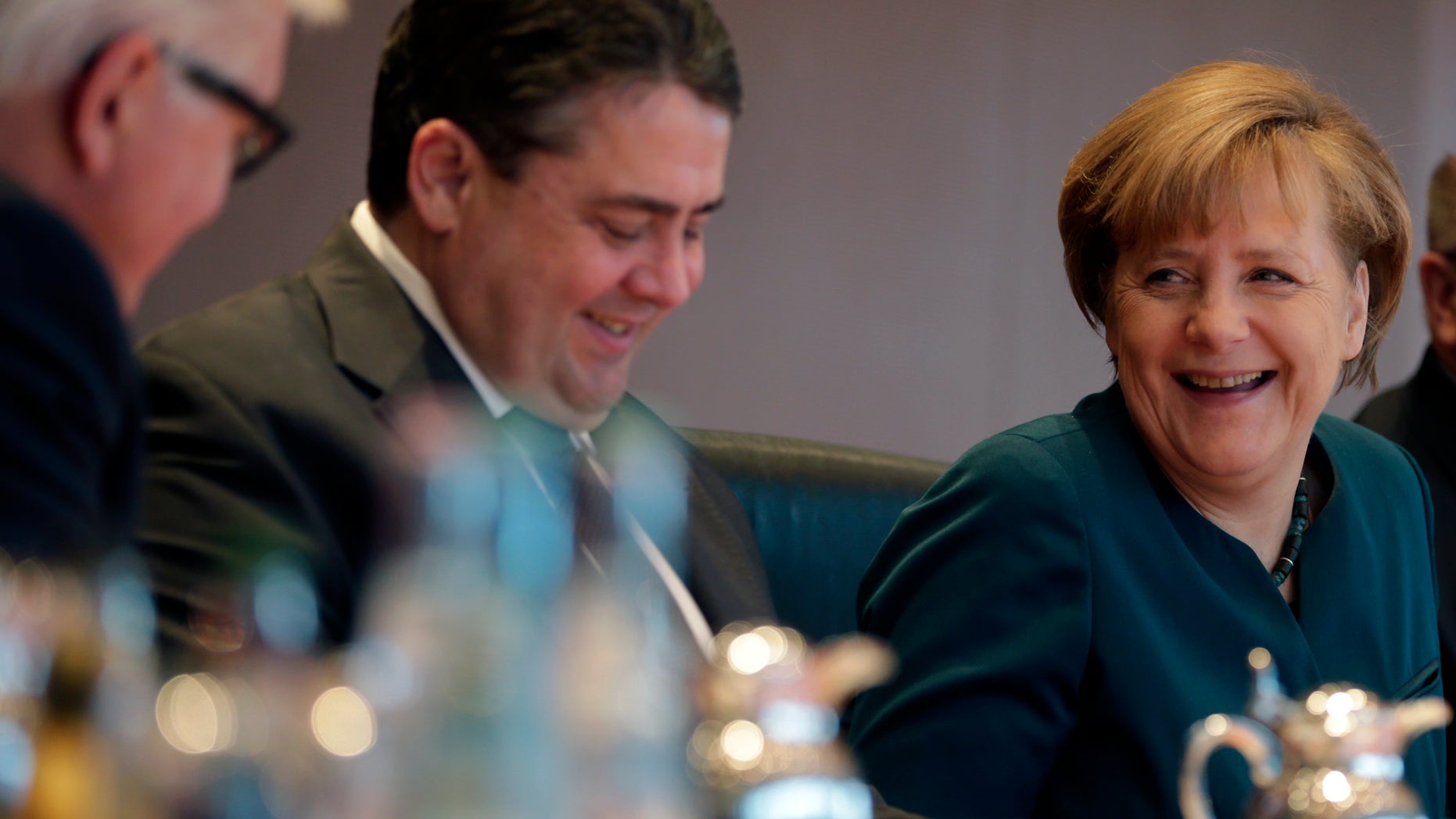 German Chancellor Angela Merkel, German Economy and Energy Minister Sigmar Gabriel and German Foreign Minister Frank-Walter Steinmeier, from right, chat at the beginning of the weekly cabinet meeting at the chancellery in Berlin, Germany, Wednesday, Jan. 15, 2014. (AP Photo/Michael Sohn)