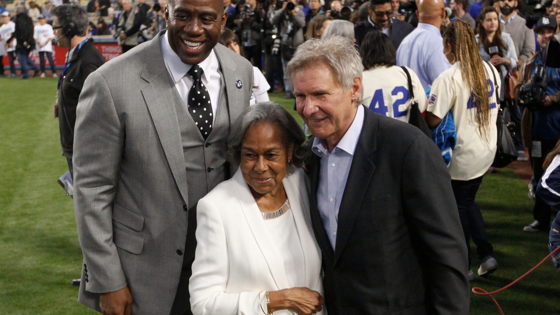Los Angeles Dodgers owner Magic Johnson, left, Rachel Robinson, widow of baseball player Jackie Robinson, center, and actor Harrison Ford pose for photos during a Jackie Robinson Day ceremony before a baseball game against the San Diego Padres in Los Angeles, Monday, April 15, 2013. (AP Photo/Jae C. Hong)