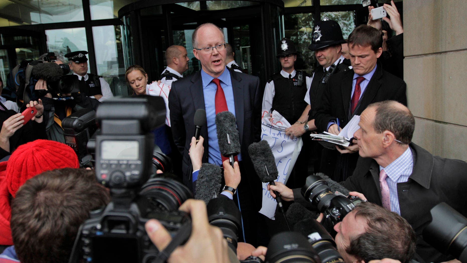 Oct. 23. 2012: George Entwistle, center, the British Broadcasting Corporation (BBC) Director General, talks to members of the media, as he departs Portcullis house in central London.