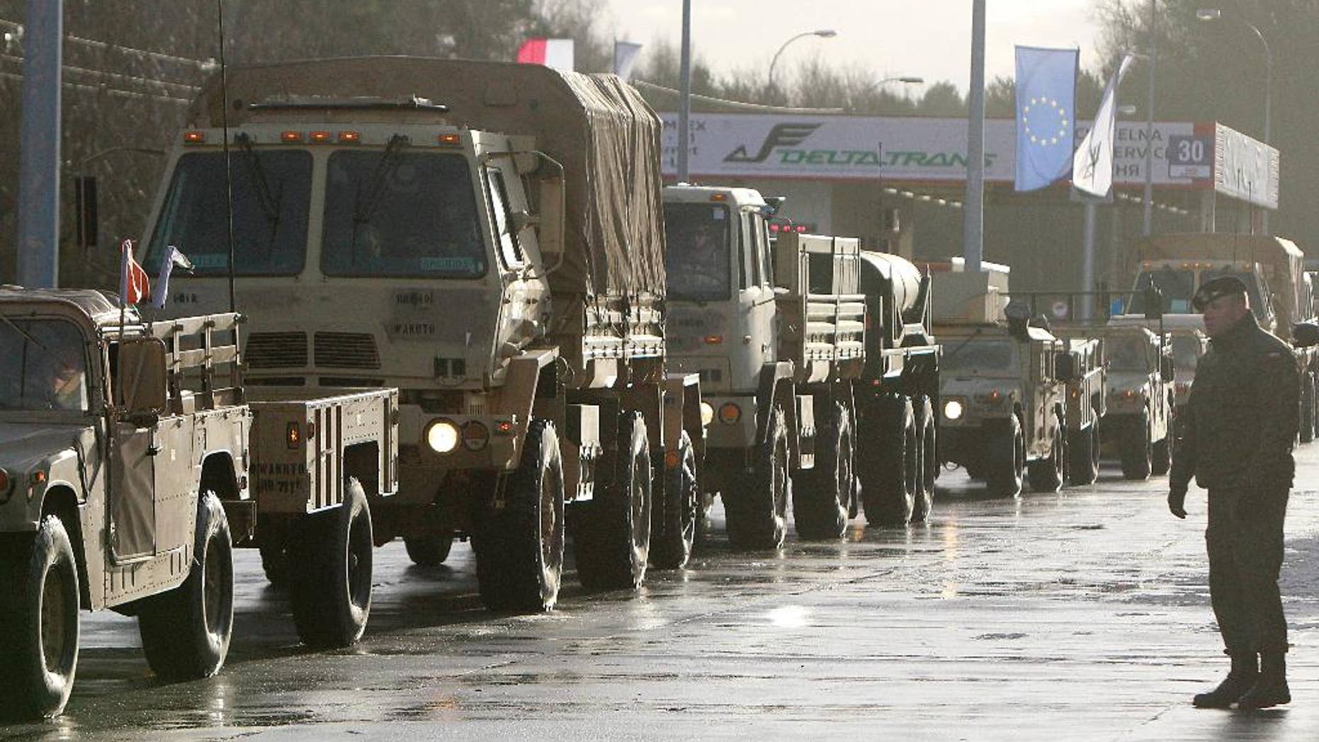 U.S. Army vehicles cross the Polish border in Olszyna, Poland, Thursday.