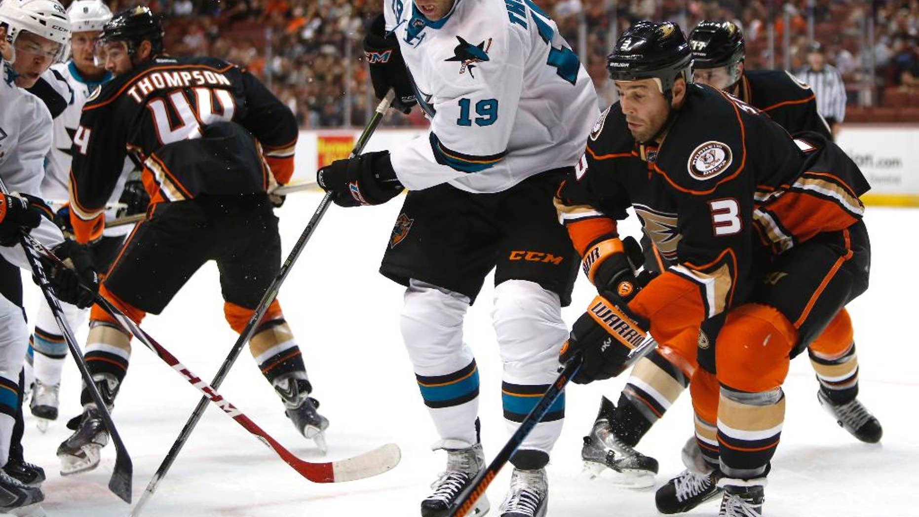 San Jose Sharks center Joe Thornton (19) works for the puck against Anaheim Ducks defenseman Clayton Stoner (3) during the first period of a preseason NHL hockey game in Anaheim, Calif., on Saturday, Oct. 4, 2014. (AP Photo/Christine Cotter)