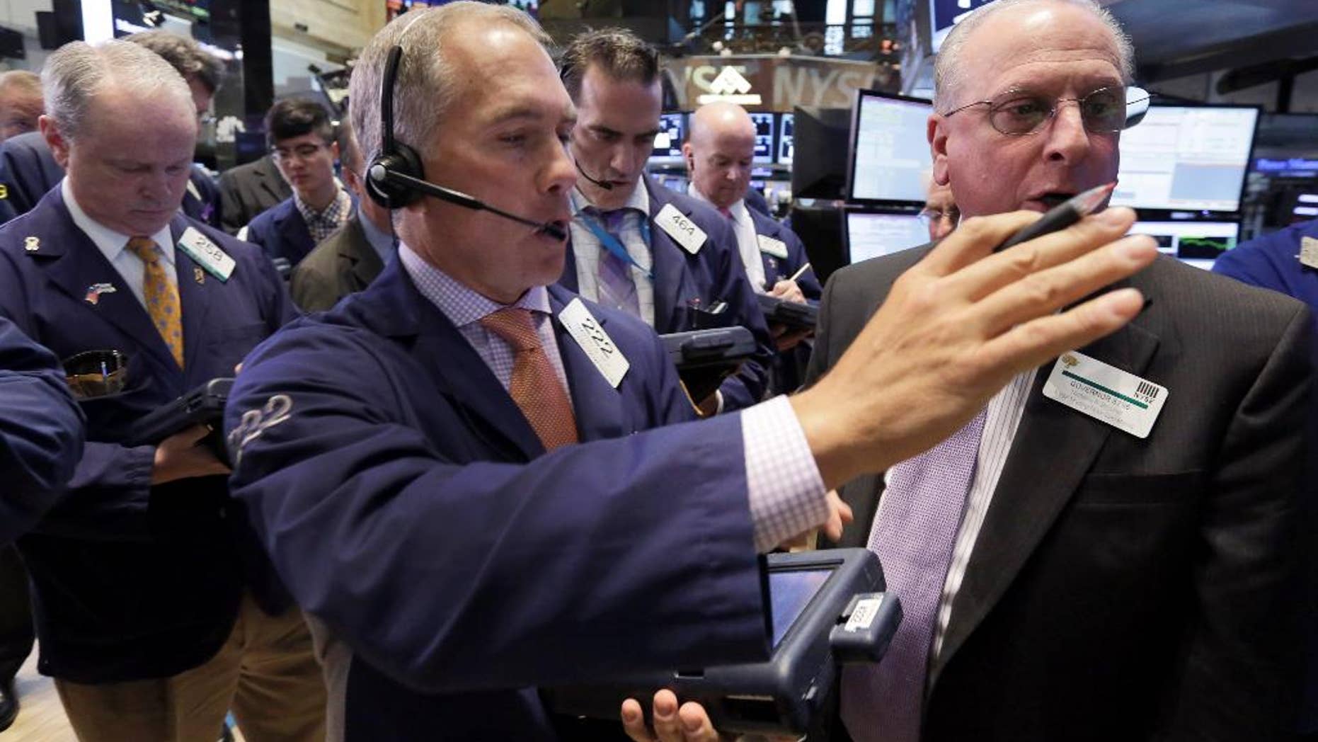 Trader Timothy Nick, center, works on the floor of the New York Stock Exchange, Tuesday, May 12, 2015. A key borrowing rate shot to a five-month high Tuesday morning, as traders around the world continued to sell off big government bonds. (AP Photo/Richard Drew)