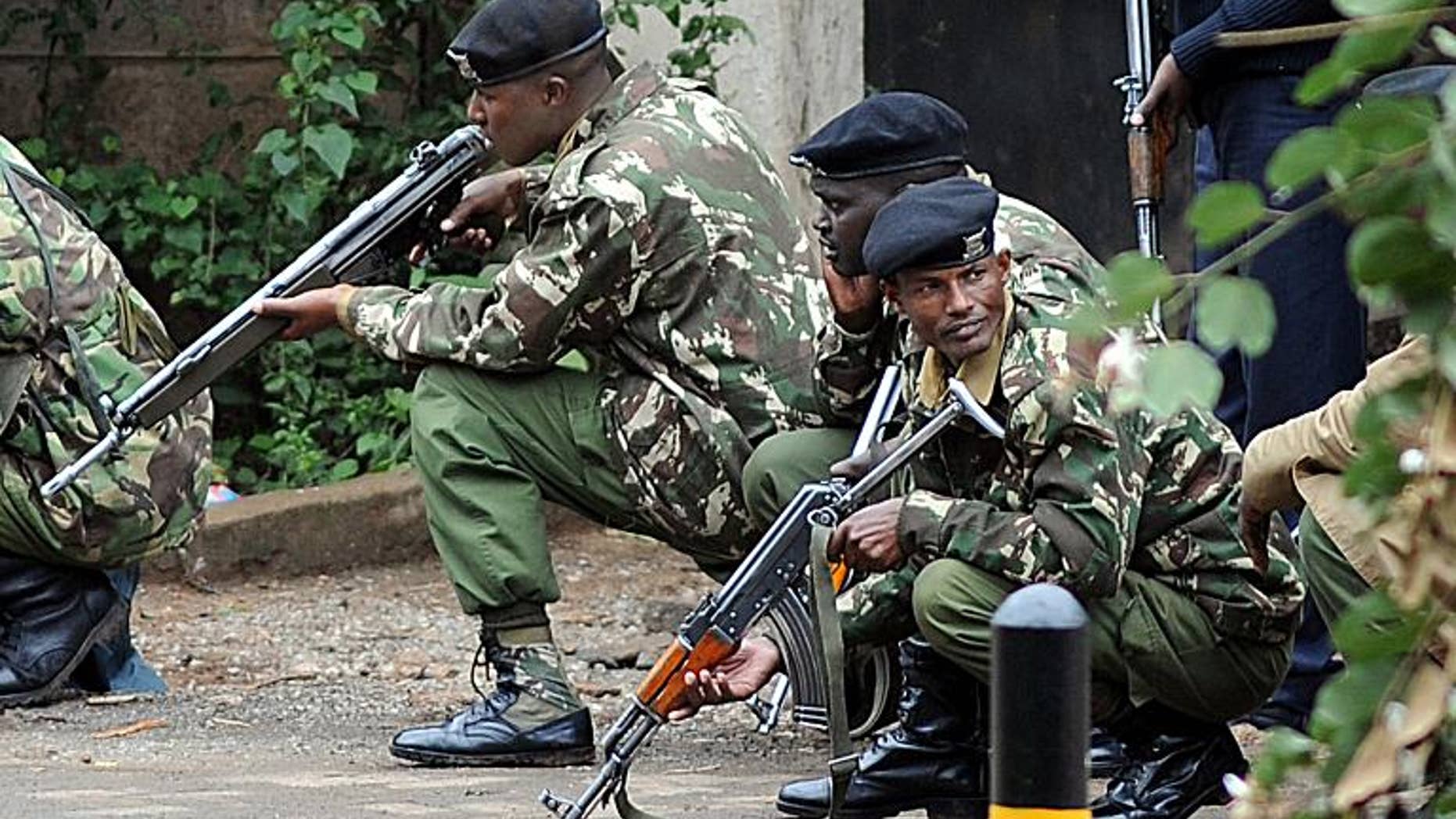 Armed Kenyan policemen take cover outside the Westgate mall in Nairobi on September 23, 2013.